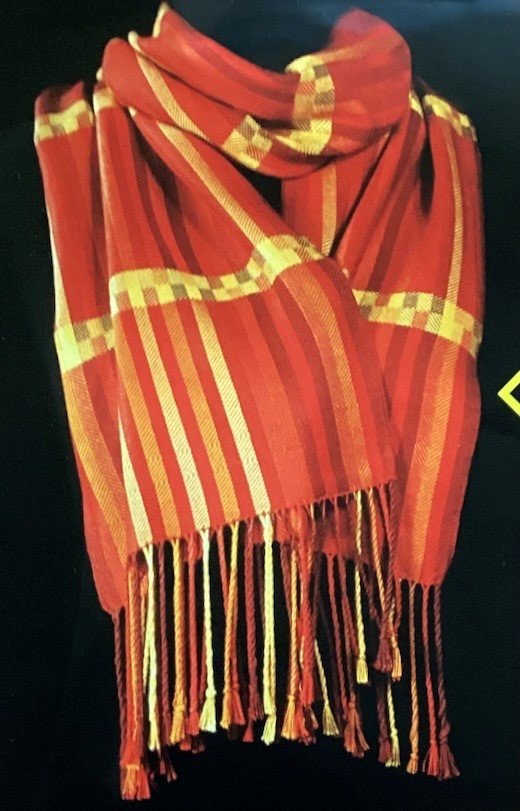A red and yellow striped woven scarf with tassels.