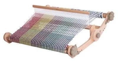 A wooden loom weaving colorful fabric with striped patterns.
