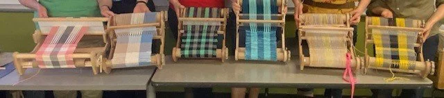 Multiple weaving looms with colorful woven strips in progress