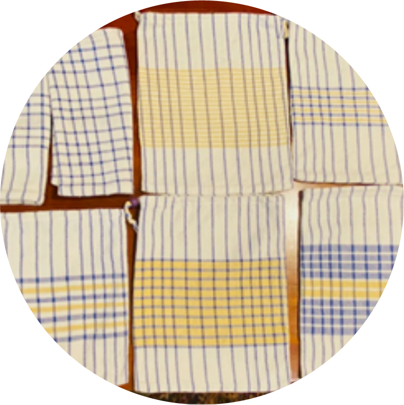 Multiple dish towels with blue and yellow plaid and striped patterns laid out on a wooden surface.