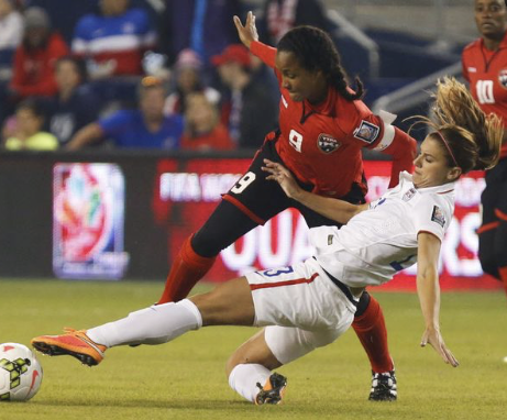 Two female soccer players competing for the ball during a match, one in a red jersey and the other in a white jersey.
