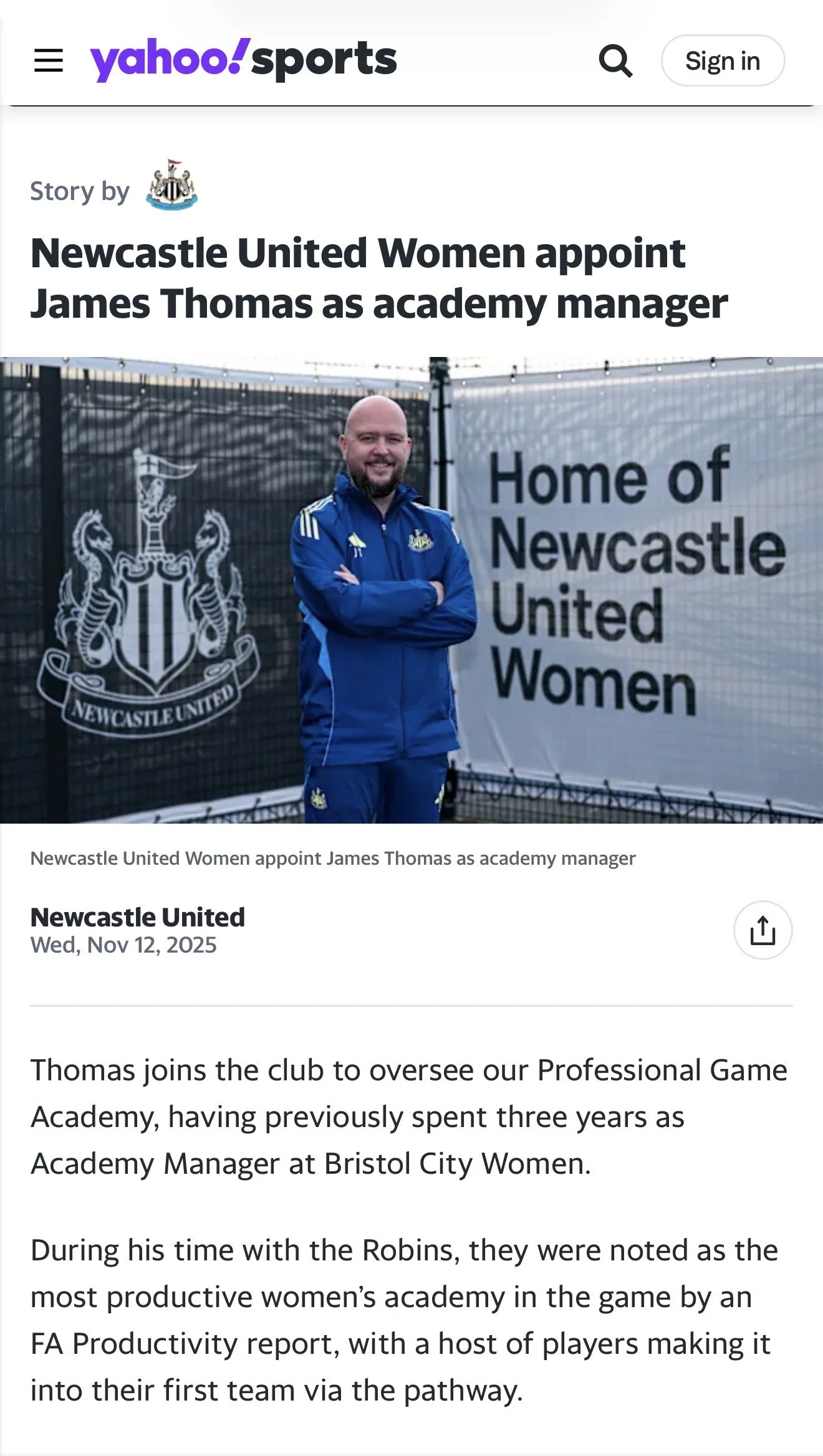 James Thomas with the Newcastle United emblem standing in front of a sign that reads 'Home of Newcastle United Women' with the Newcastle United crest, smiling with arms crossed.