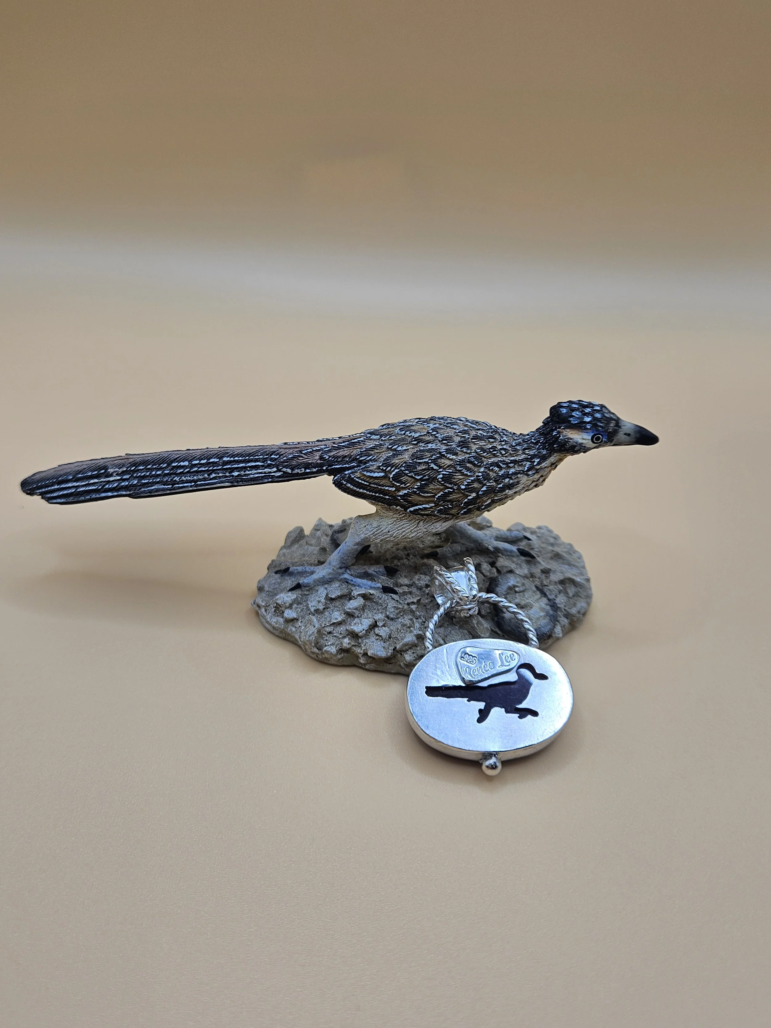 Hidden, secret roadrunner cutout with amethyst stone shinning through the sterling silver pendant.
