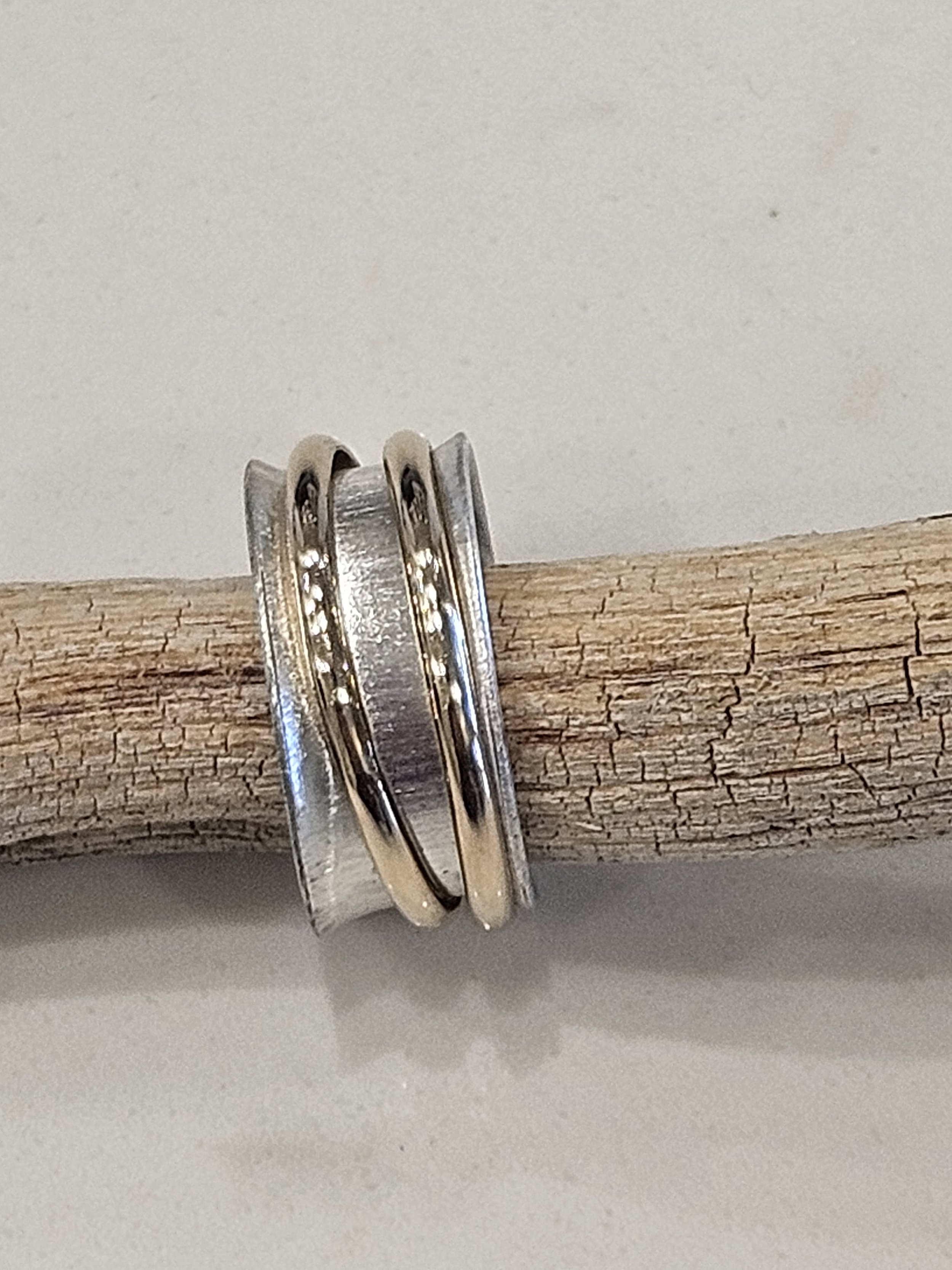 Sterling silver spinner ring with brushed finish and two 14k GF spinner bands.