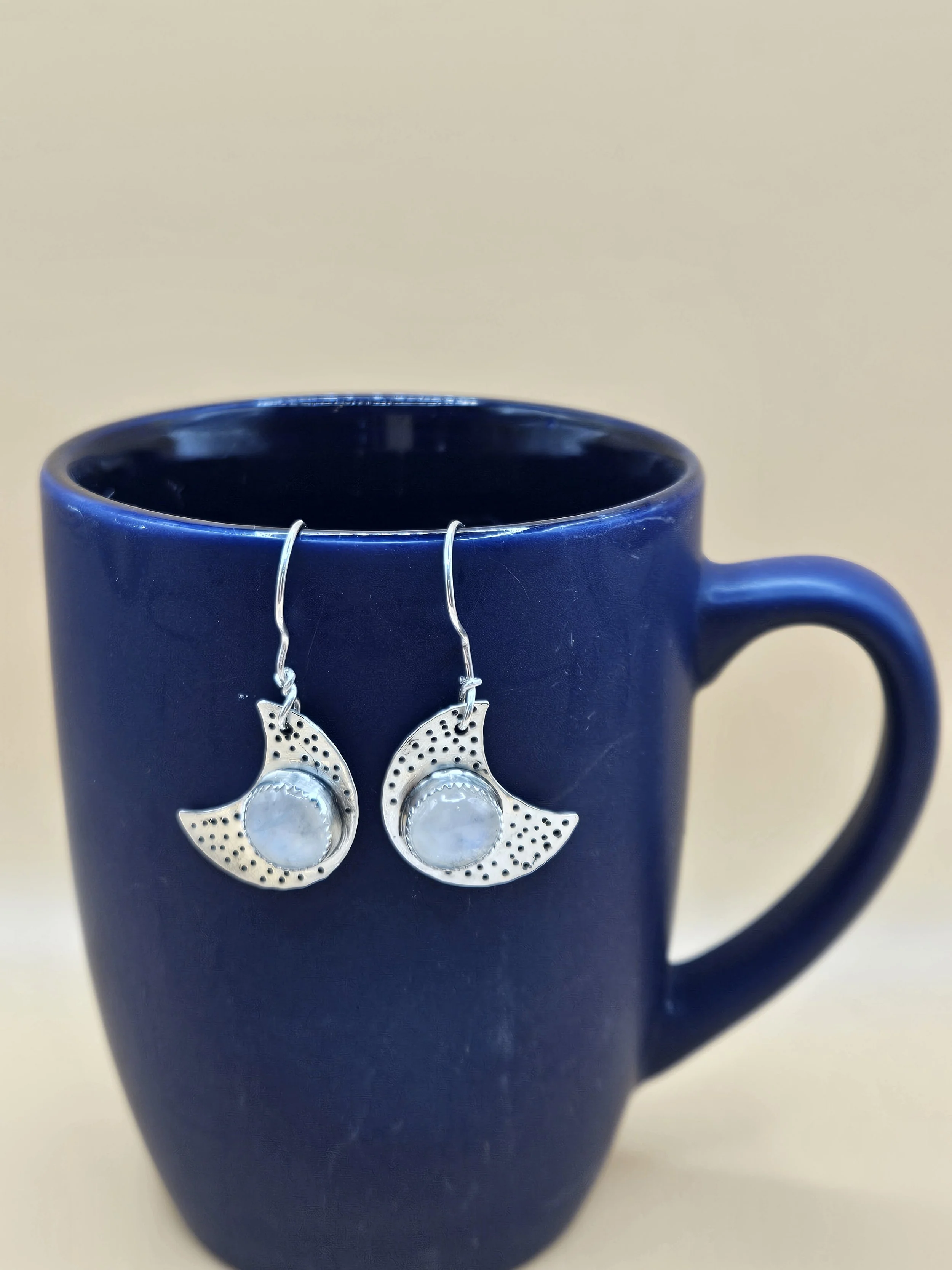 Sterling silver crescent moon earrings with starry background and rainbow moonstone gemstones. 