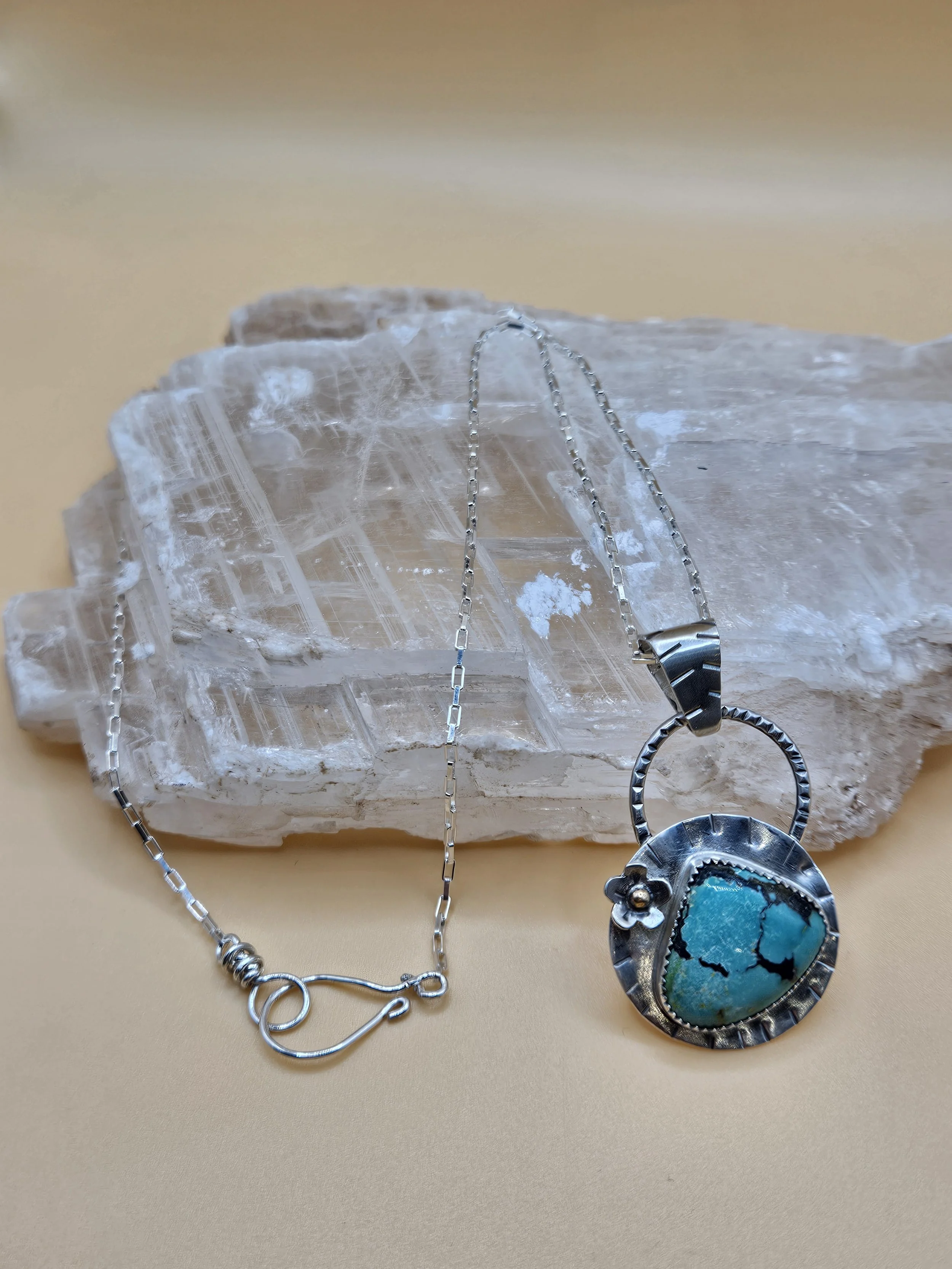 Sterling silver turquoise pendant with a silver flower accent on handmade sterling silver chain.