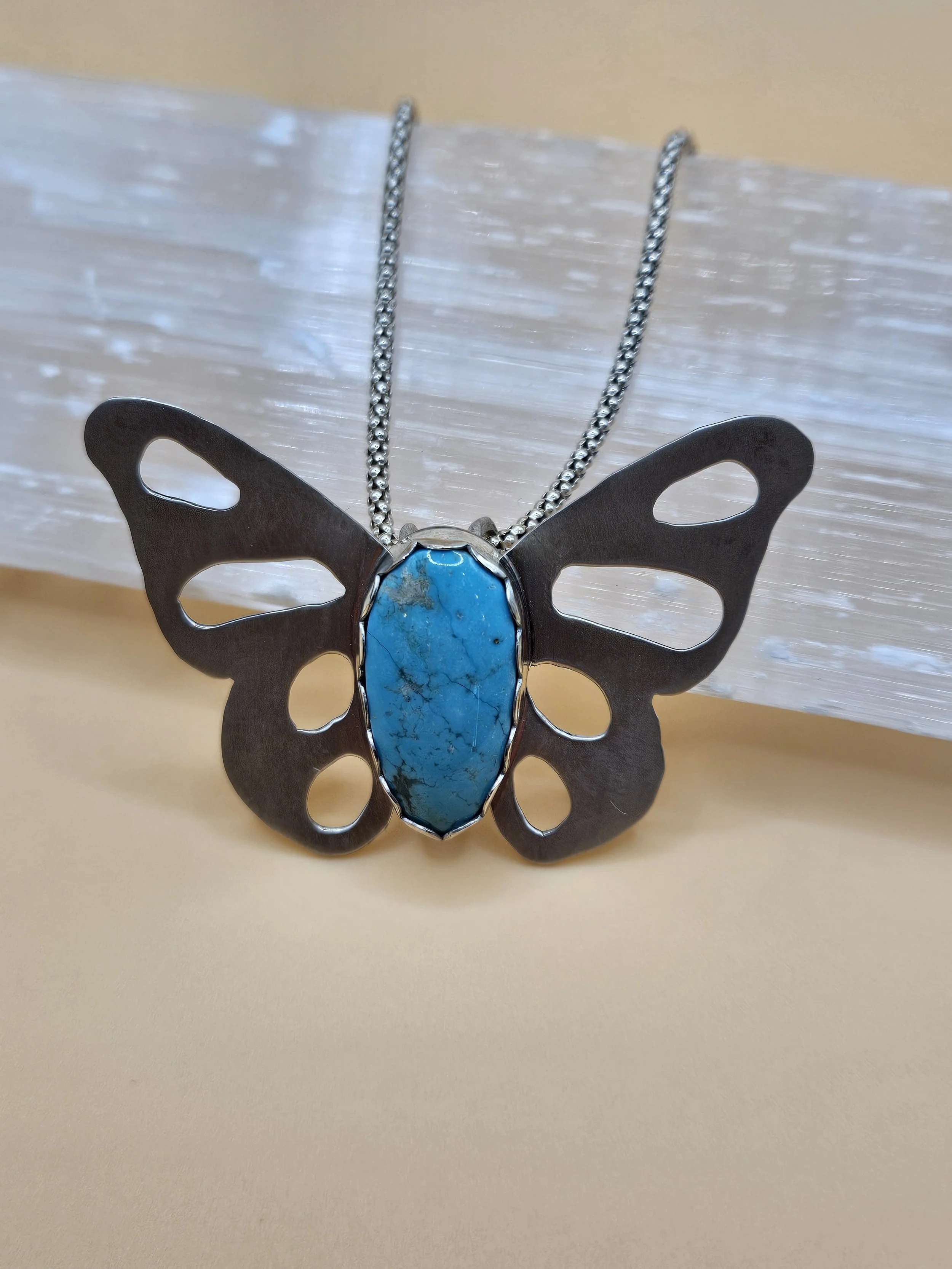 Sterling silver butterfly pendant necklace with Kingman turquoise stone in the center.