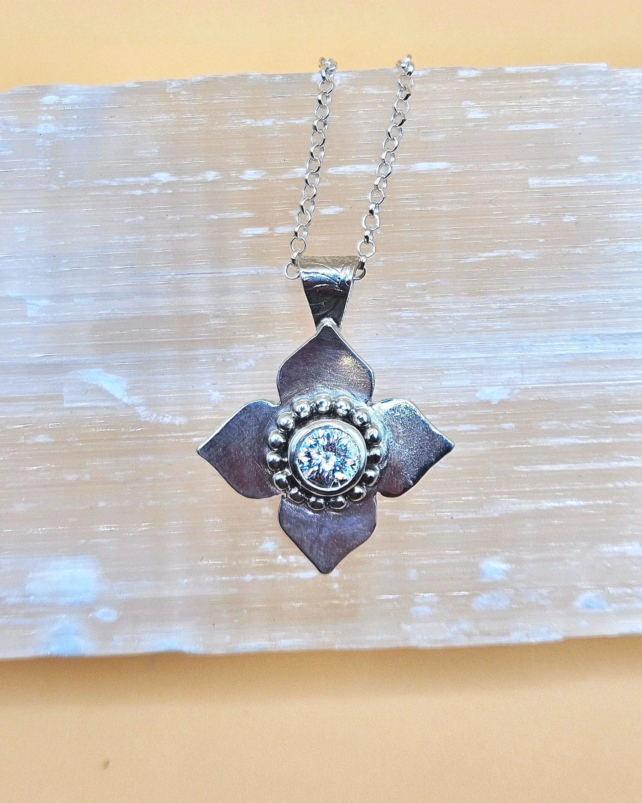 Sterling silver flower pendant with a lab grown diamond.
