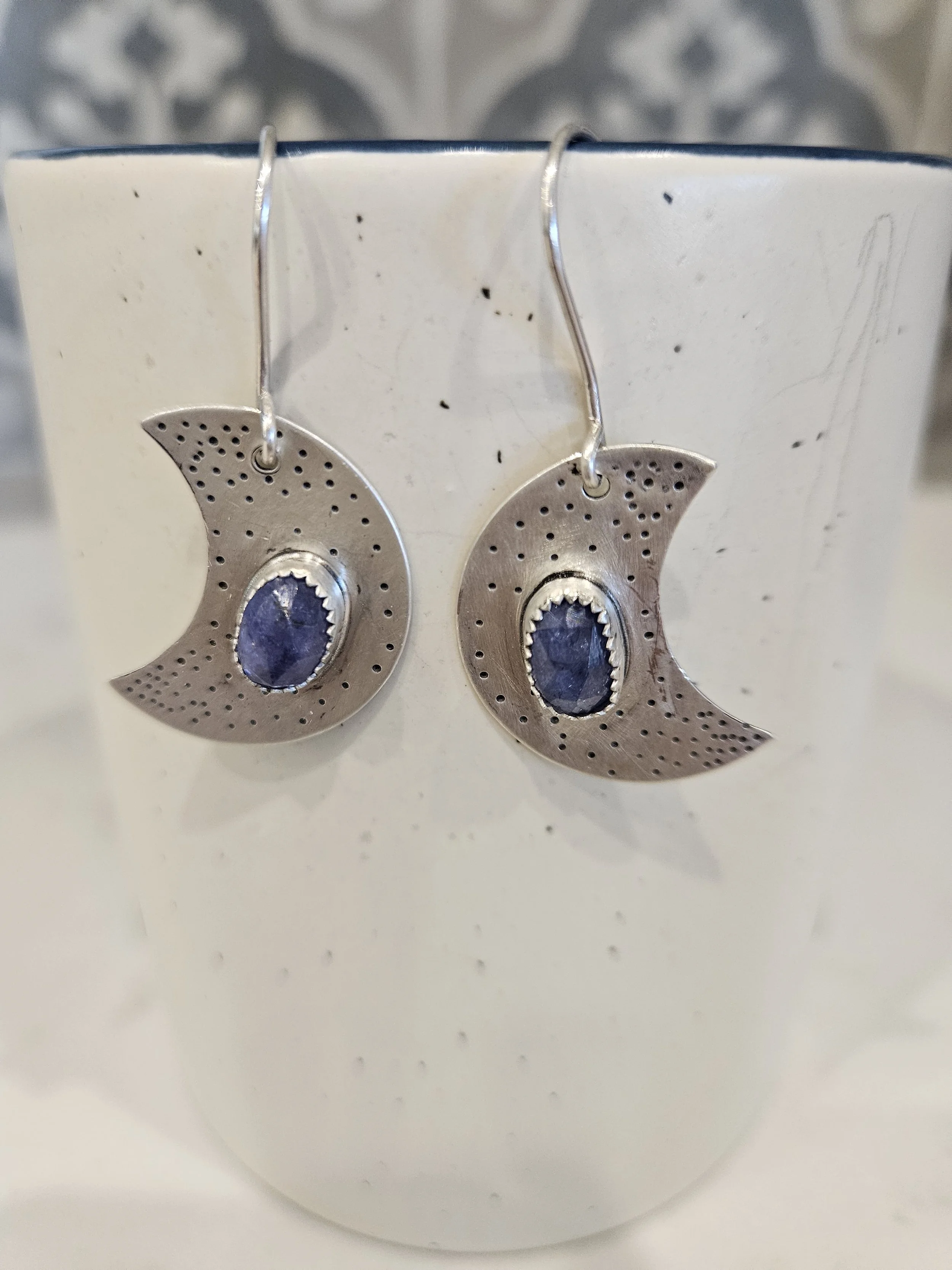 Sterling silver crescent moon earrings with starry texture and Iolite gemstones.