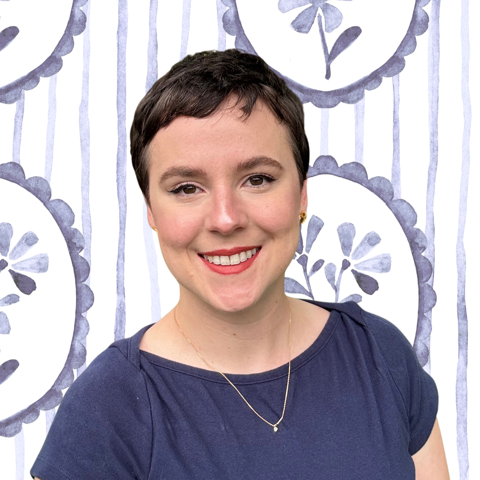 Therapist, Ryann Taylor, a woman with short dark hair, wearing a navy blue shirt, gold earrings, and a delicate gold necklace, smiling against a white background with purple floral and striped patterns.