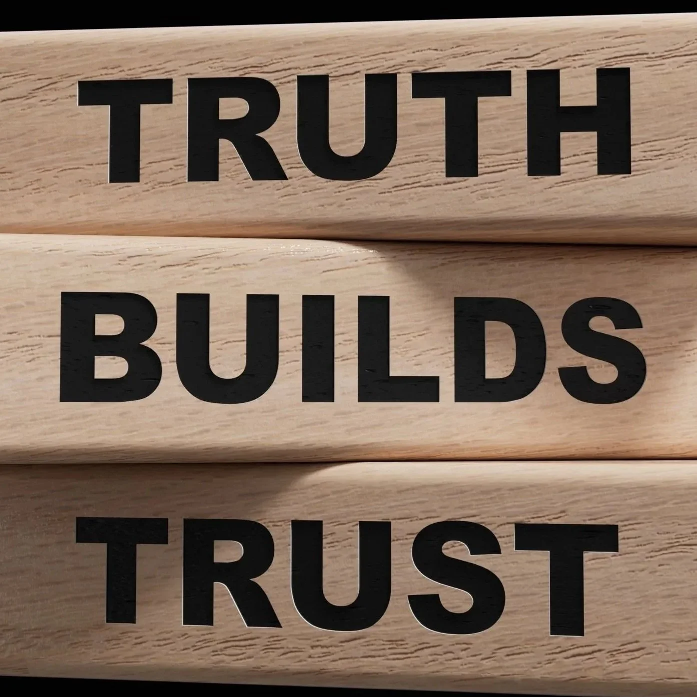 Close-up of wooden blocks with words 'TRUTH,' 'BUILDS,' and 'TRUST' printed in black letters.