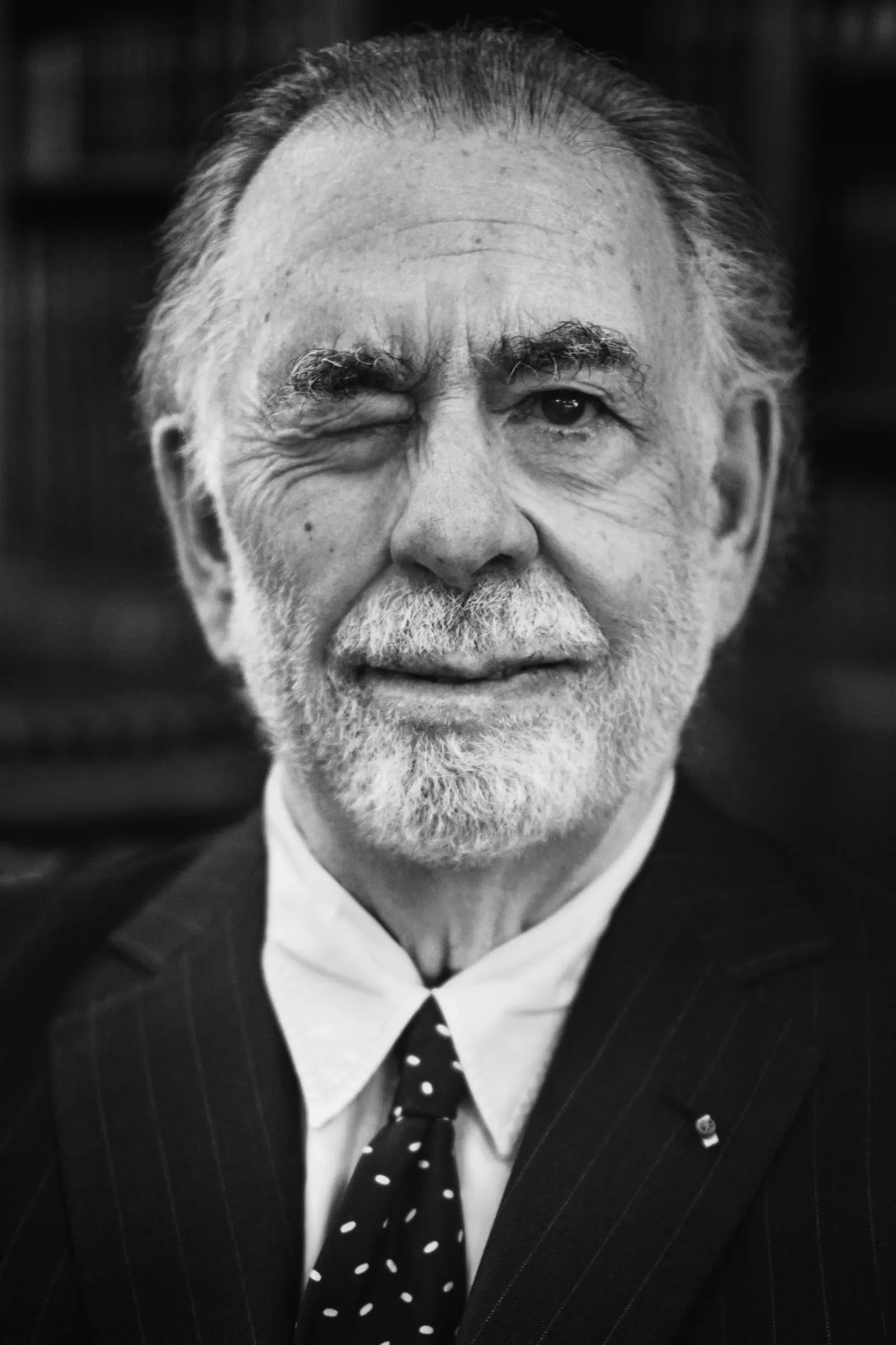 Elderly Francis Ford Coppola winking. He's responsible for some of the movie industry's all time best movies. "Apocalypse Now," based on "Heart Of Darkness," is one of his most well known films. Father to Sophia Coppola.