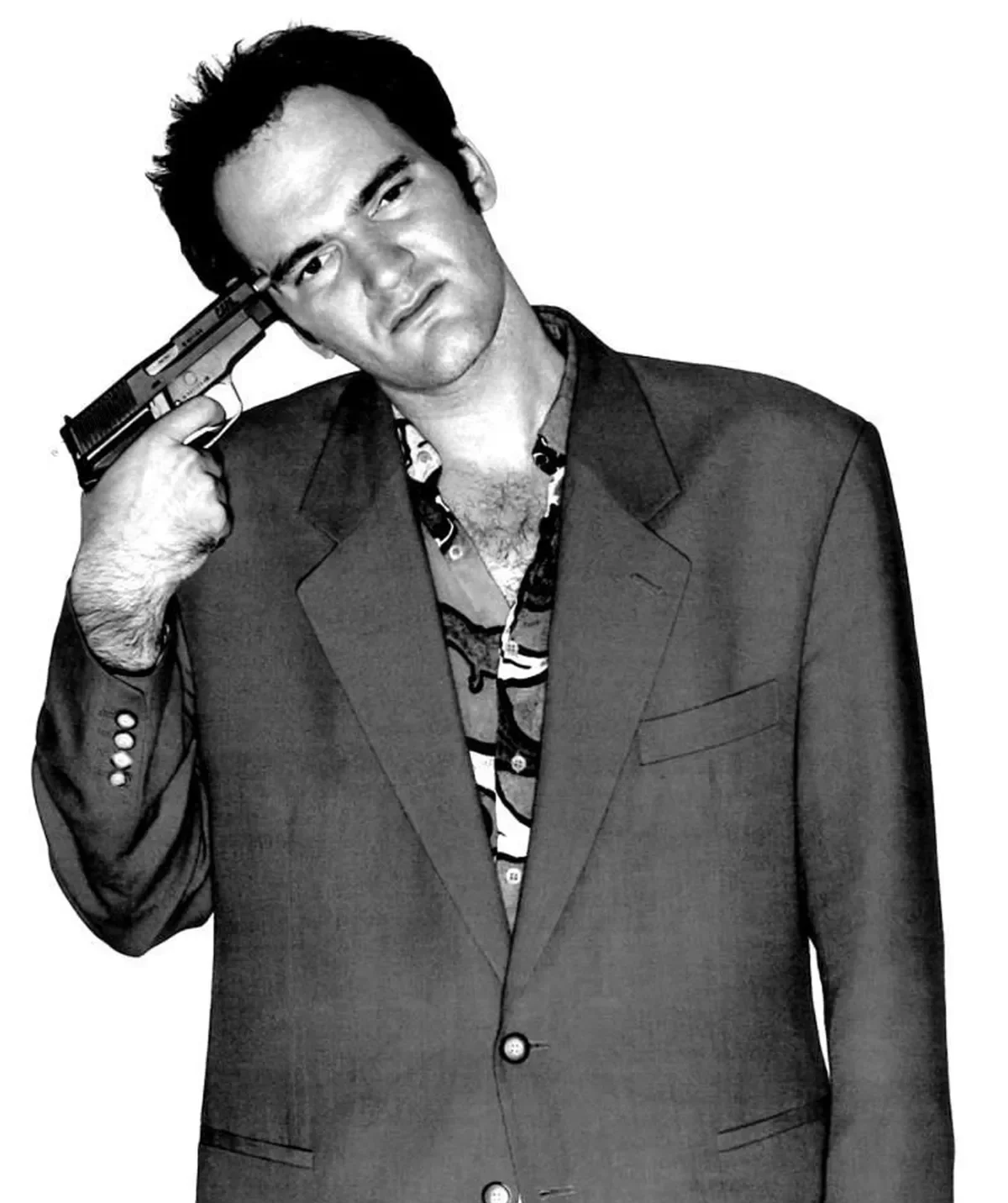 Quentin Tarantino in a suit, satirically holding a gun to his head, with a quirky expression, in a black and white. The photo was taken after his success, as a young Auteur.