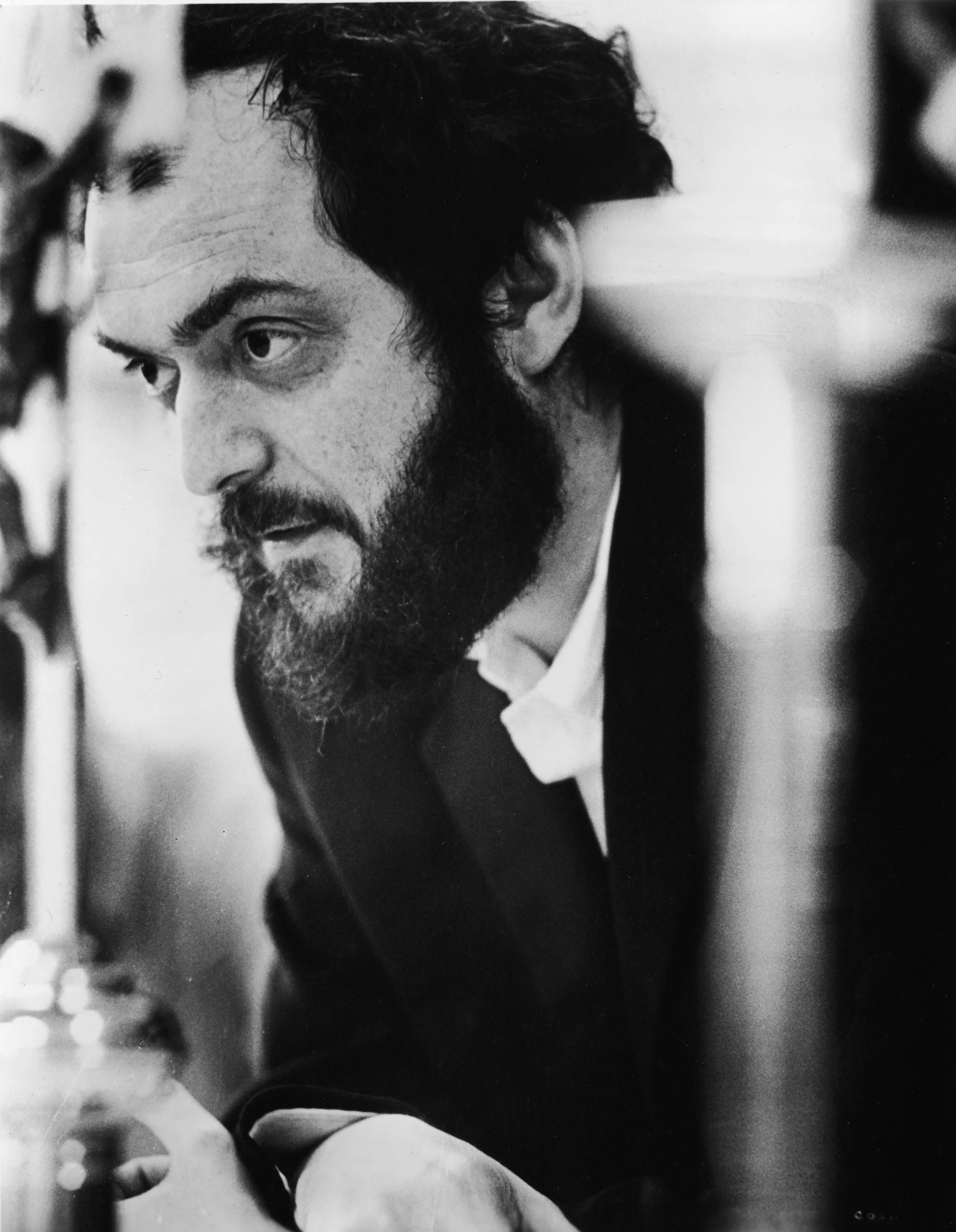 Black and white close-up photograph of Stanley Kubrick, working on the set of a film.