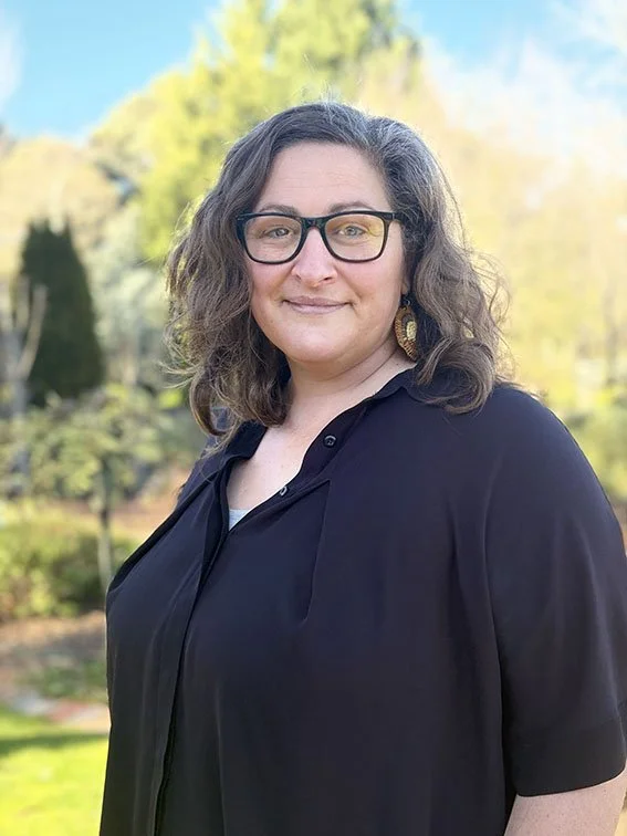 This is an image of Siobahn Altham. She is looking at the camera and is wearing black glasses and a black shirt