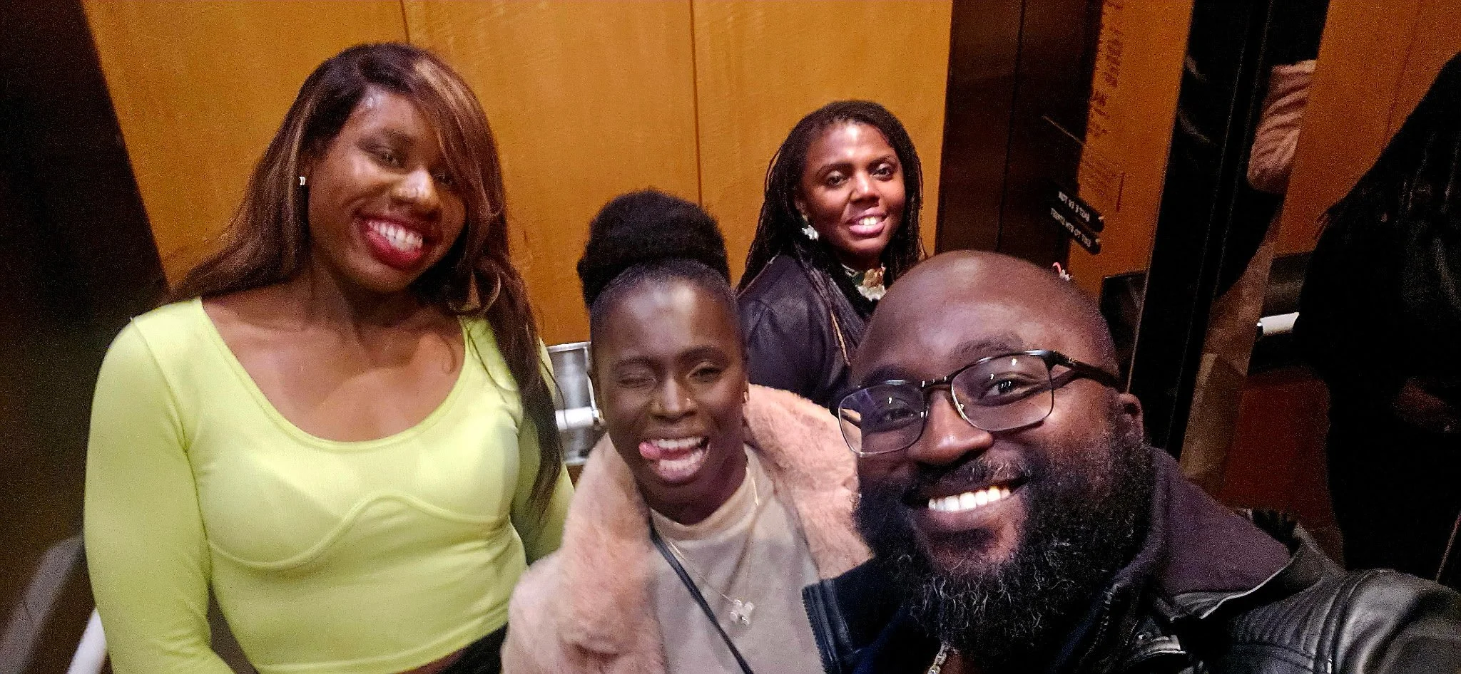 Liam and Moyo posing for a selfie indoors with family.