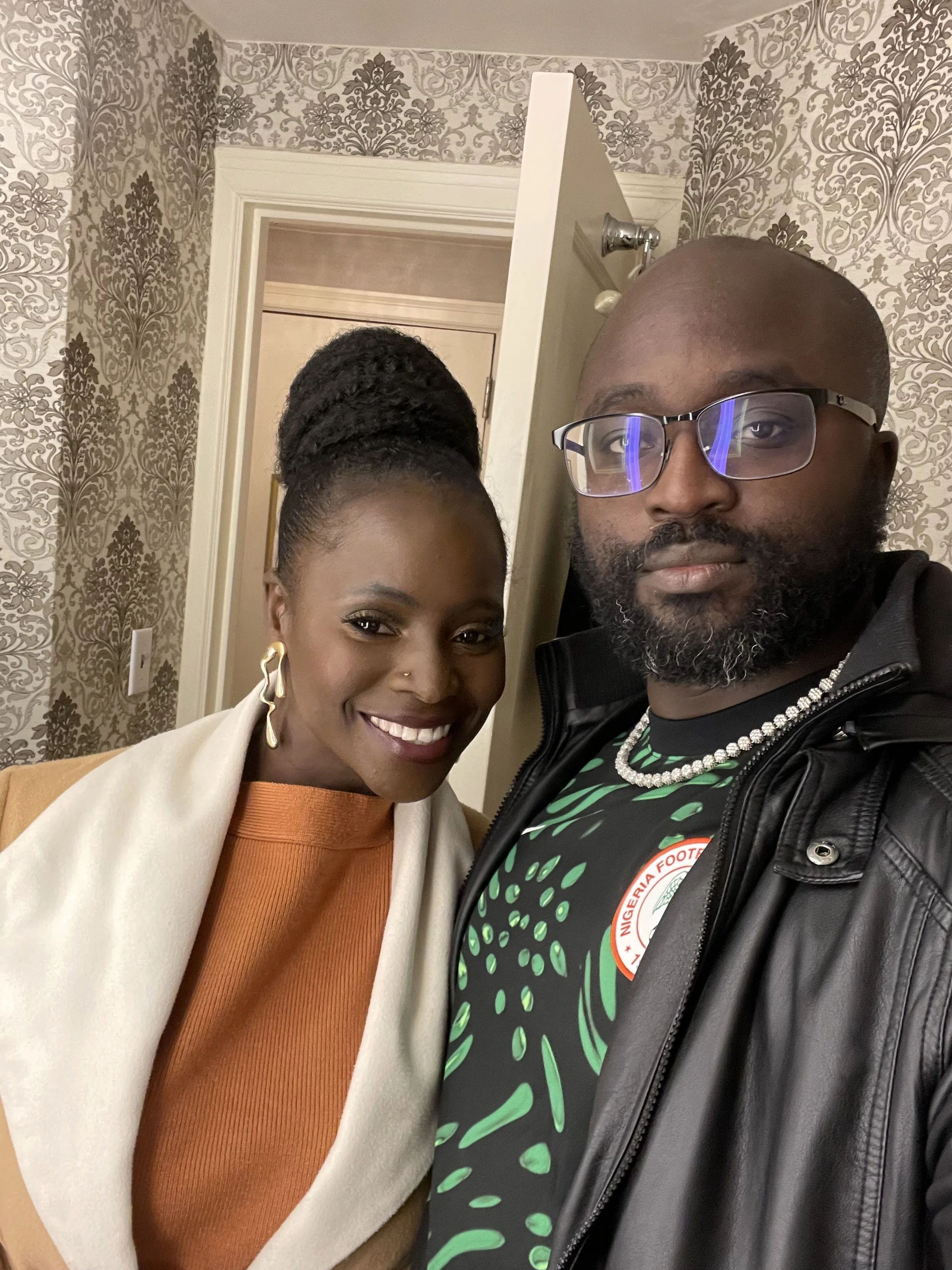 Moyo and Liam are taking a selfie indoors. 