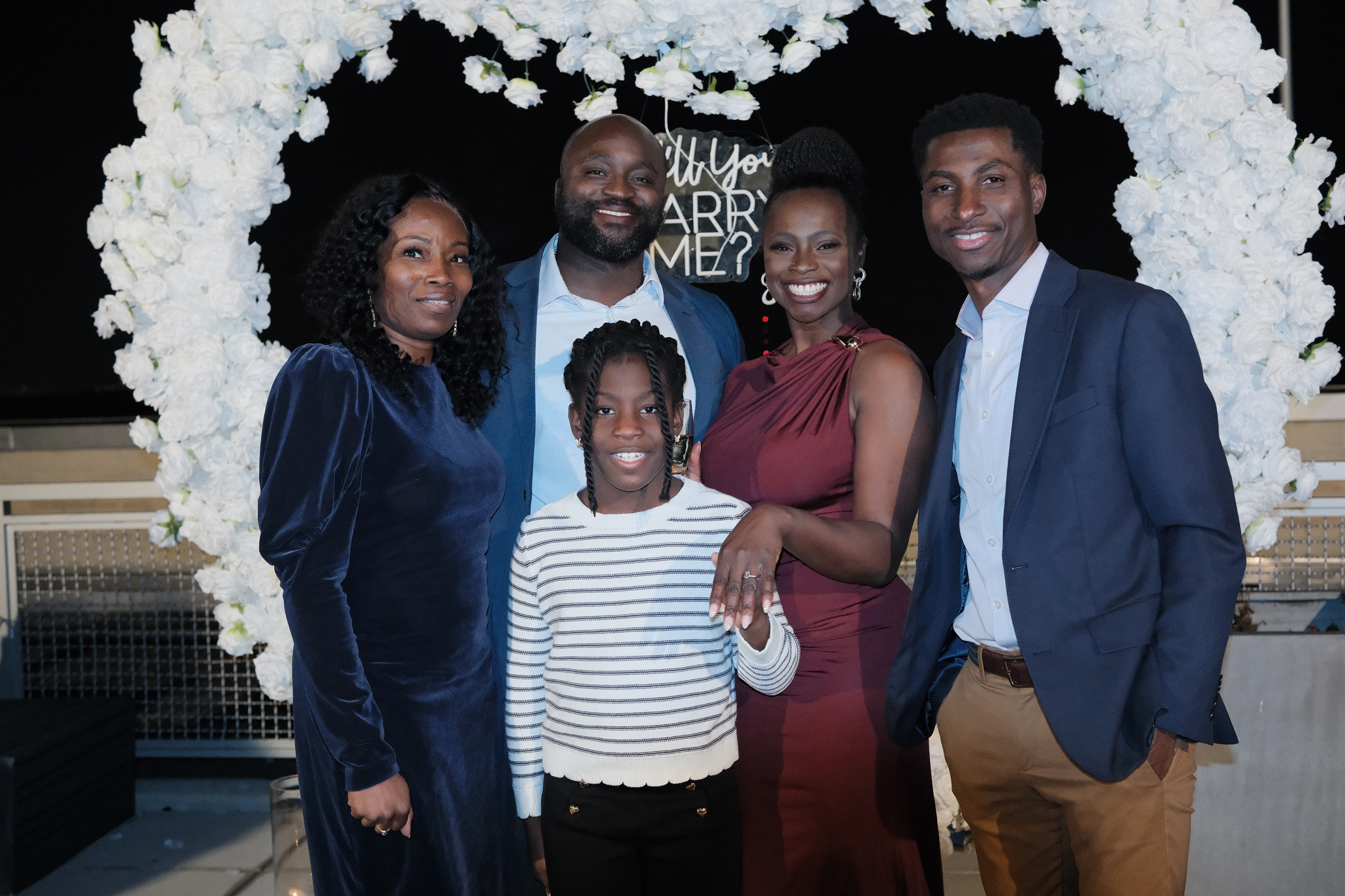 Moyo and Liam posing together at their engagement celebration, with Moyo's uncle's family.