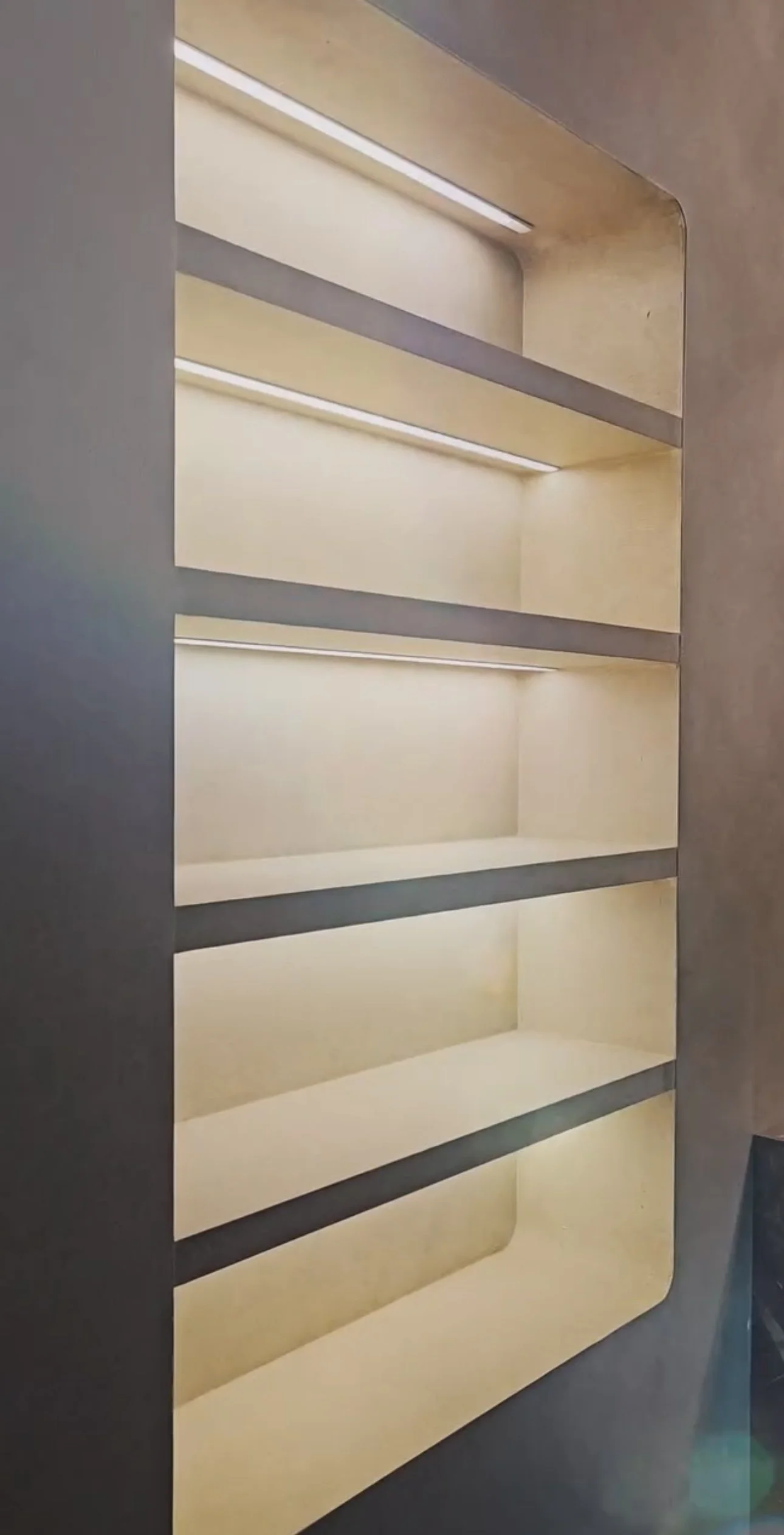 Interior of a beige and gray empty shelving unit with multiple shelves