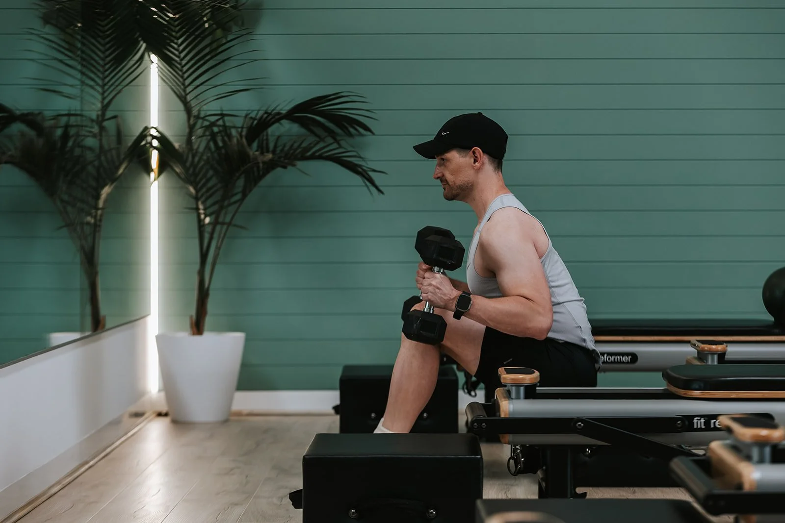 Sage Pilates Brunswick West © | Man exercising with dumbbells in a fitness studio