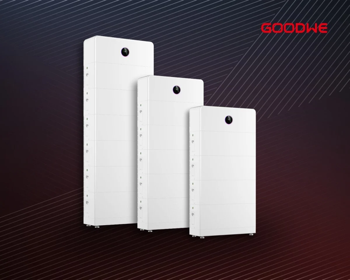 Three large white rectangular battery units of different sizes with a black circular logo on top, arranged in front of a dark background with diagonal lines and the red text "GOODWE" in the top right corner.