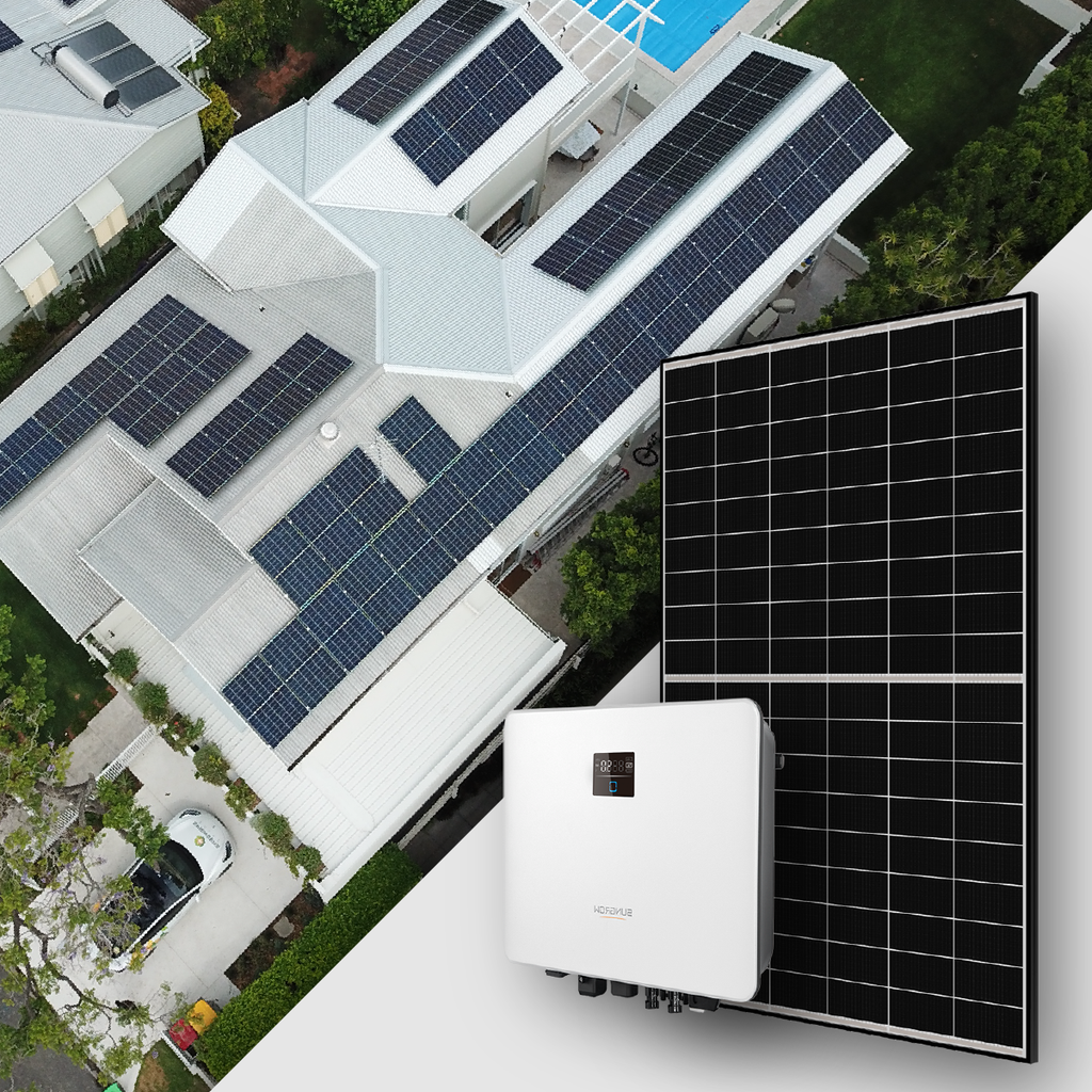 Aerial view of a house with multiple solar panels on the roof, a large solar panel setup and a white inverter in the foreground.