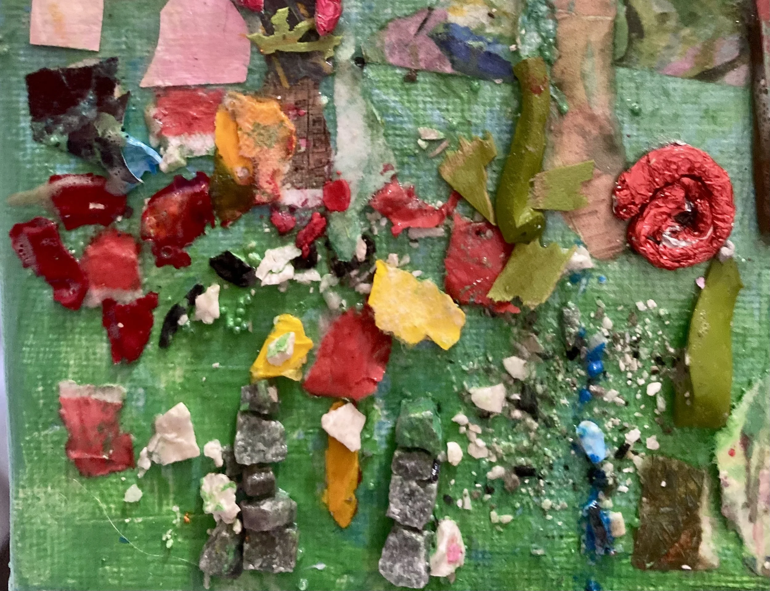 A colorful array of paint chips and debris scattered across a green surface.