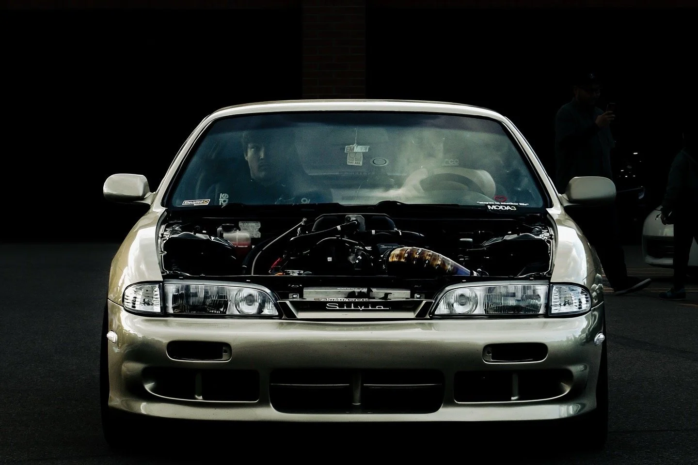 Front view of a silver Toyota Silvia two-door coupe with the hood open, revealing its engine.
