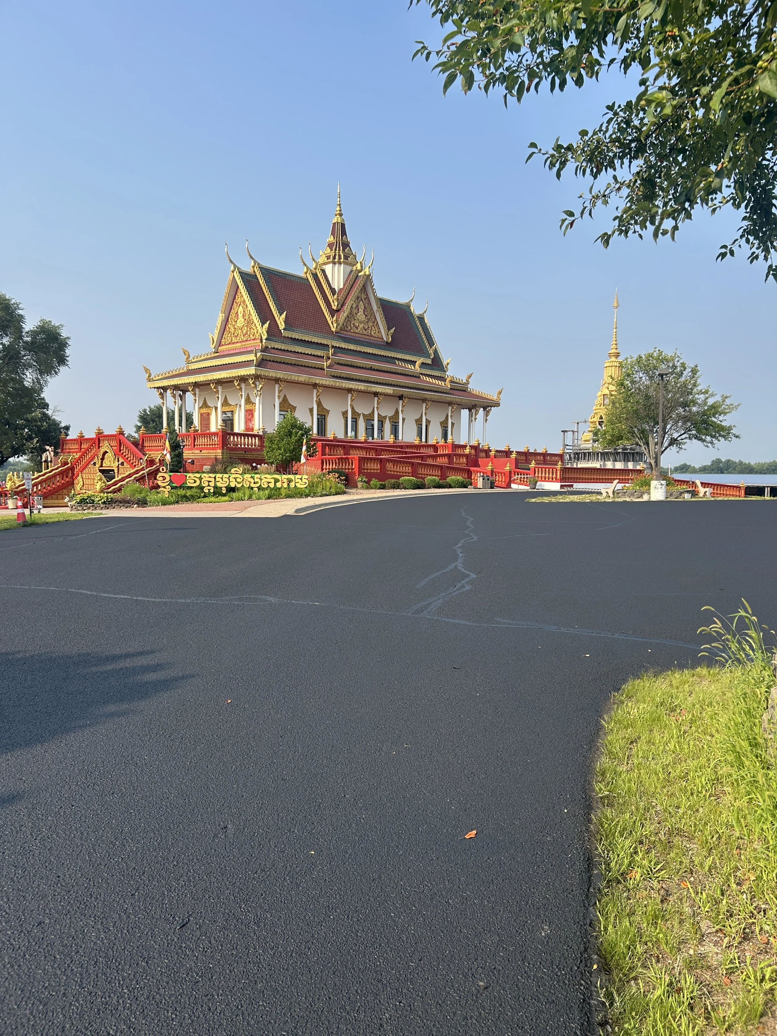 The main parking lot at Watt Munisotaram temple in Minnesota, showcasing freshly completed asphalt sealcoating and expert crack filling by 7 County Sealcoating, pictured just before the final line striping.