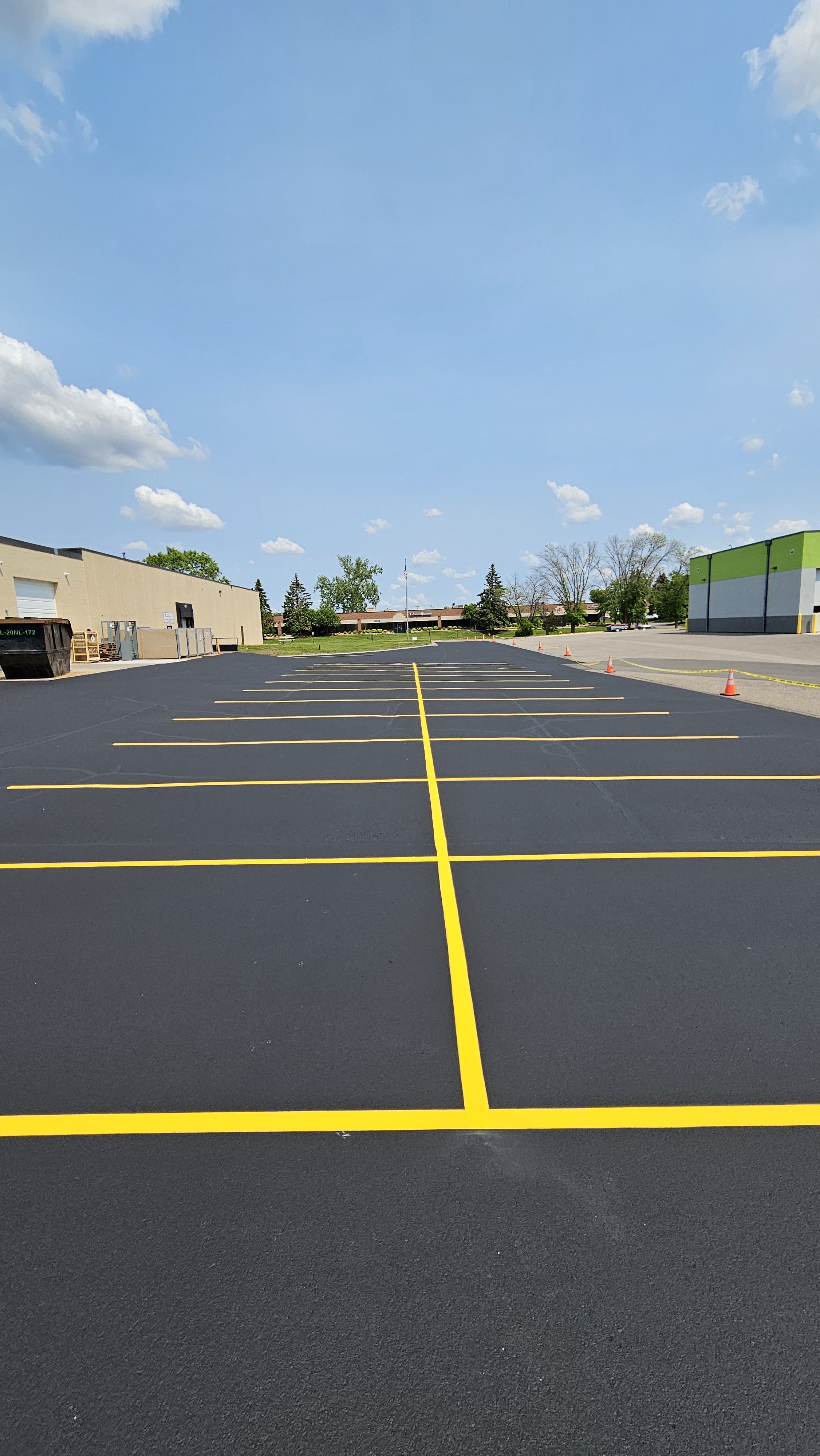 Completed commercial asphalt sealcoating and bright yellow line striping project at American Midwest Power in Plymouth, MN. Professional parking lot maintenance and safety marking by 7 County Sealcoating.