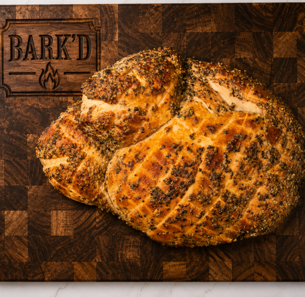 Two seasoned, cooked chicken breasts resting on a wooden cutting board with a 