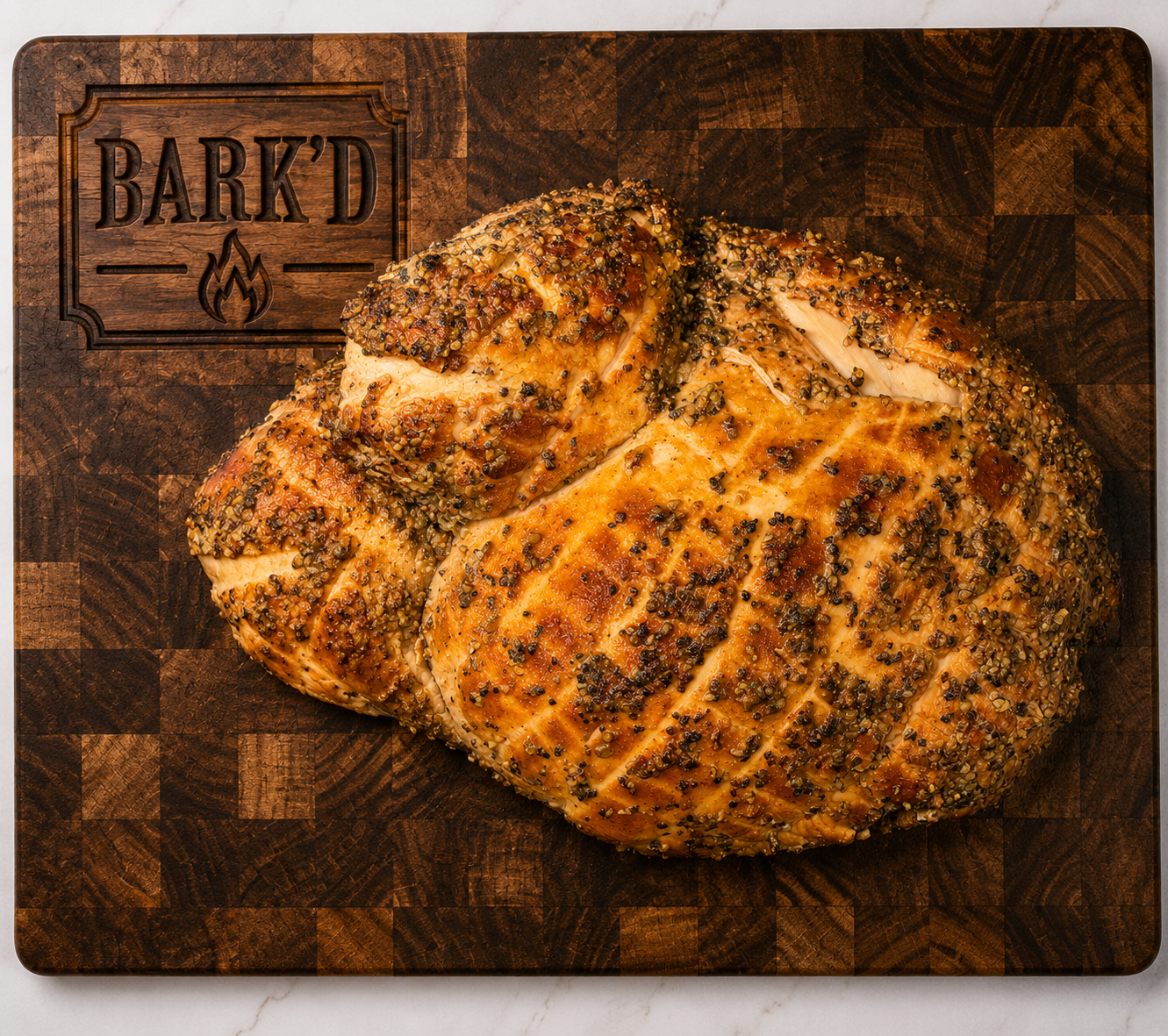 Herb-crusted roasted chicken on a wooden cutting board with a Bark'd logo.
