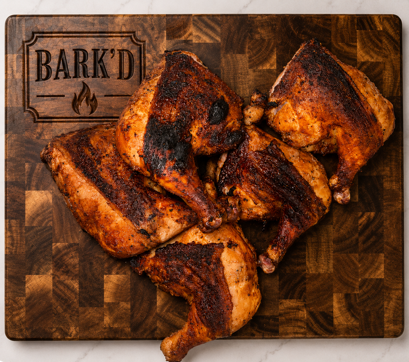 Grilled chicken quarters on a wooden cutting board with a 'Bark'd' logo and flame icon engraved on it.
