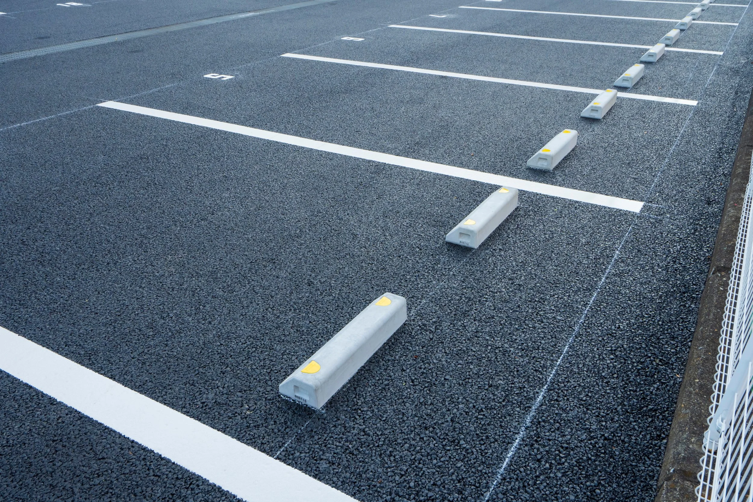 空の駐車場と白線、仕切りのブロックが並べられている様子。