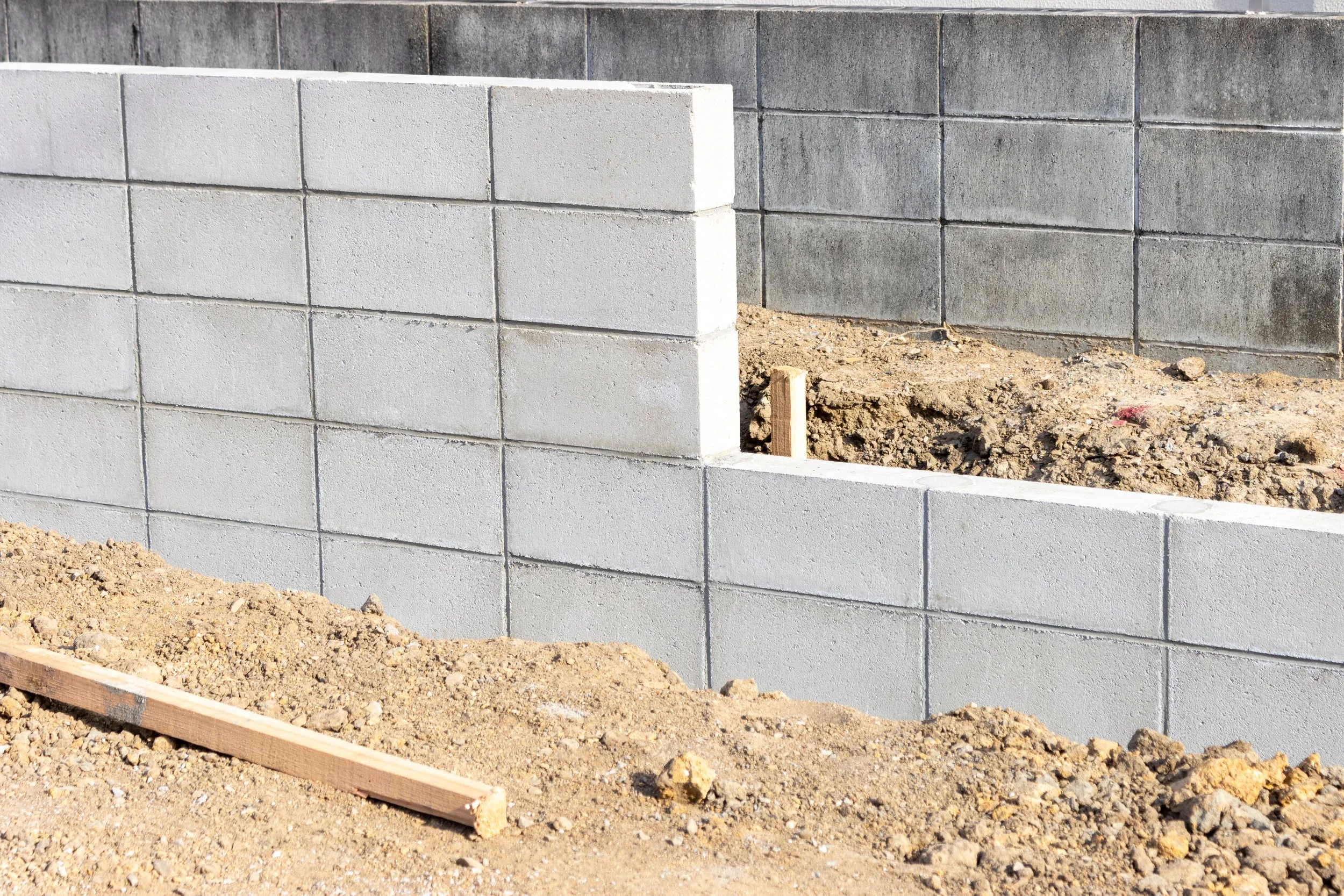 コンクリートブロックの壁と土壌のある建設現場の写真
