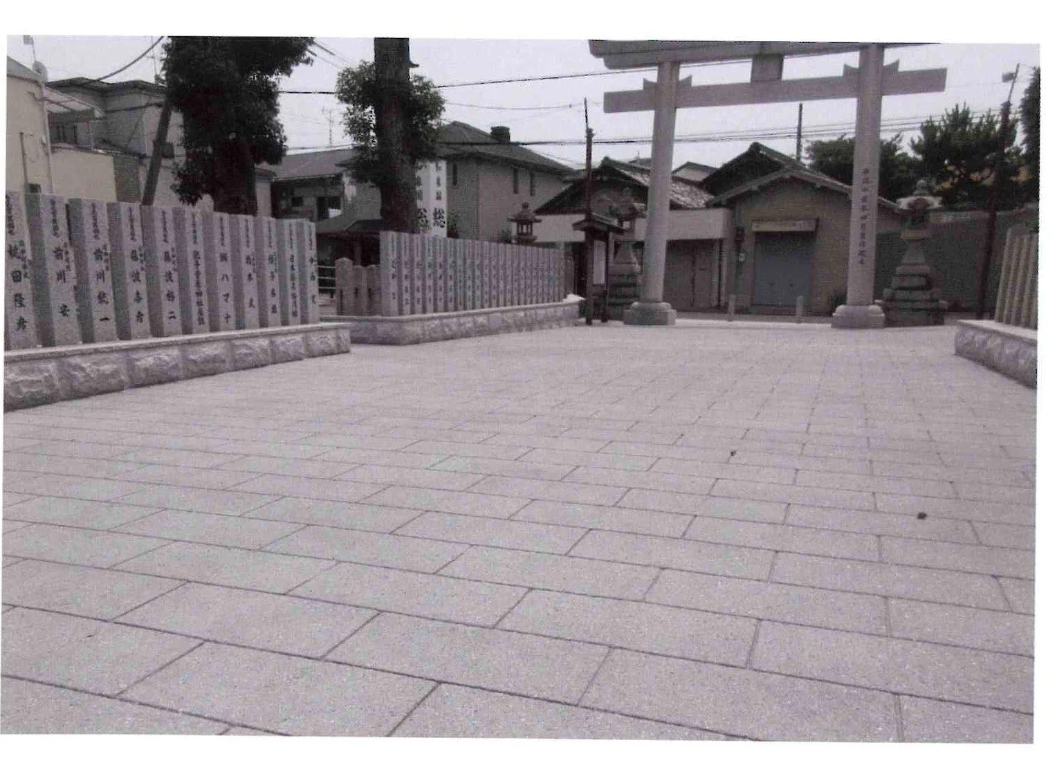 静かな神社の境内、石の鳥居と説明板が設置されている風景