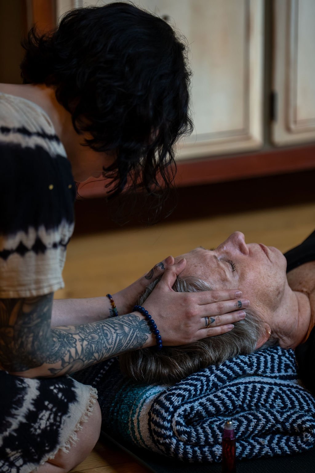 Shamanic Reiki practitioner working the energy centers on a client's head during a healing session at Earthed Studio in Chicago