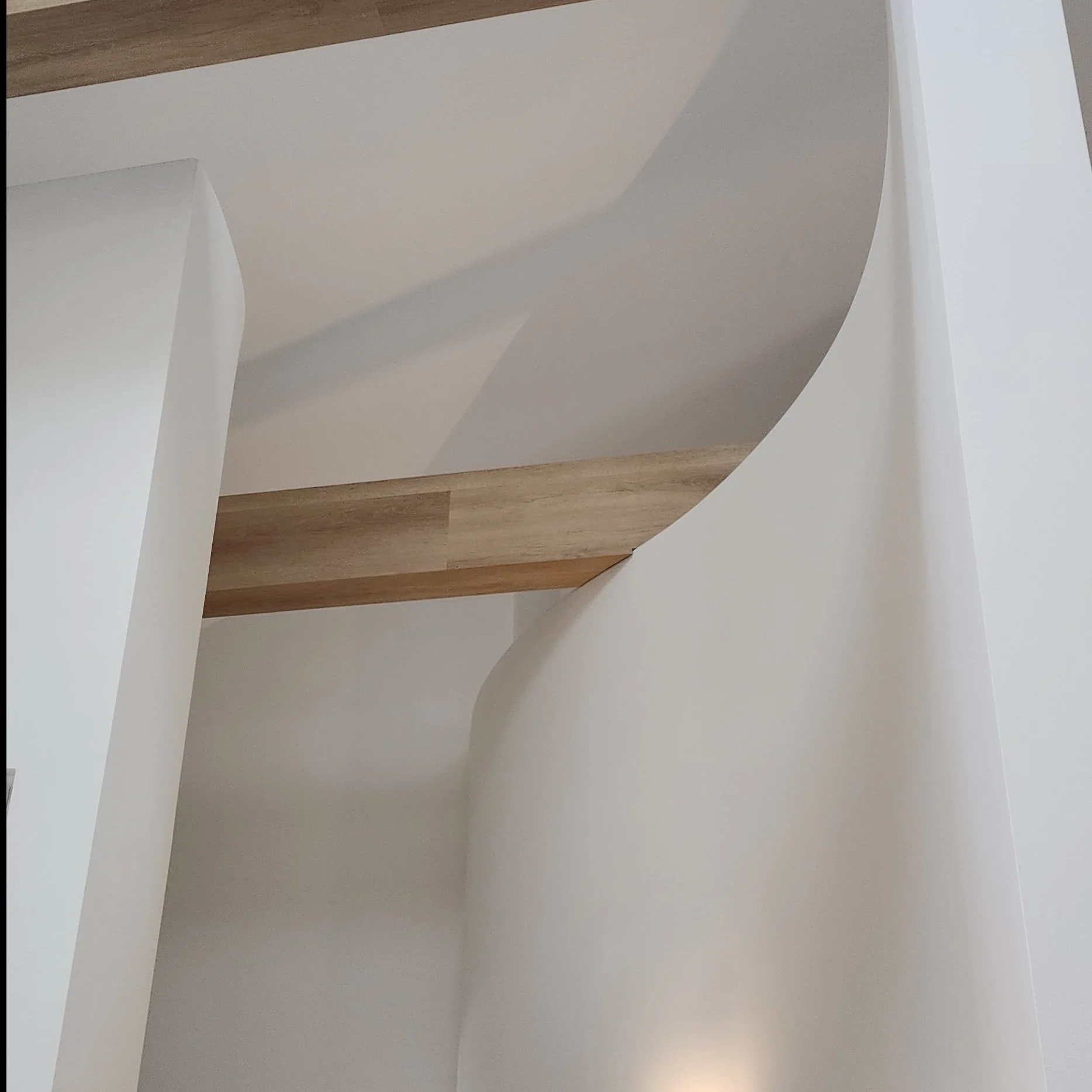 Close-up of spherical white objects on a white surface, with a wooden floor visible in the background.