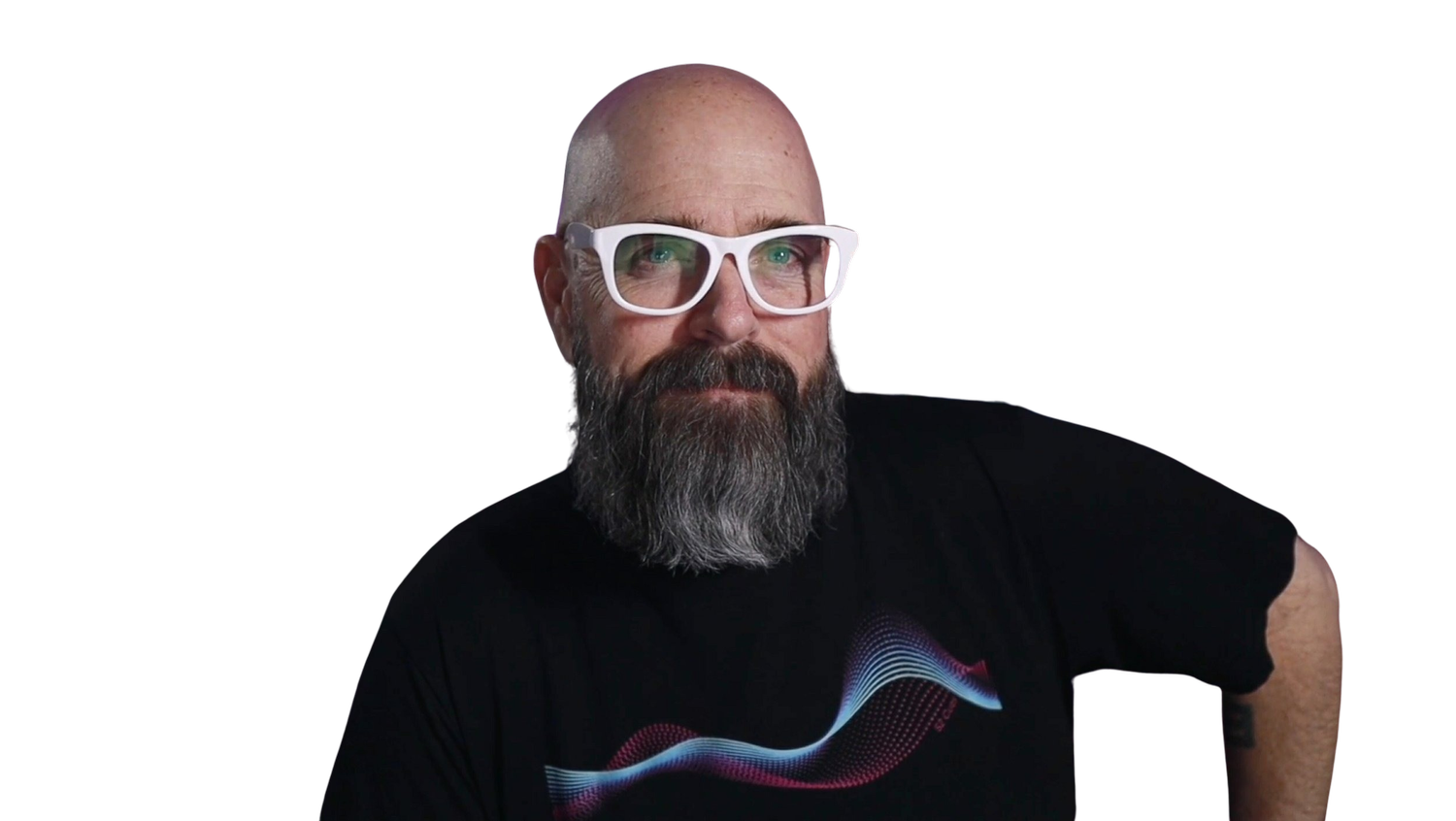 A middle-aged man with a beard and glasses, wearing a black t-shirt with a colorful wave pattern, looking at the camera with a confident expression.