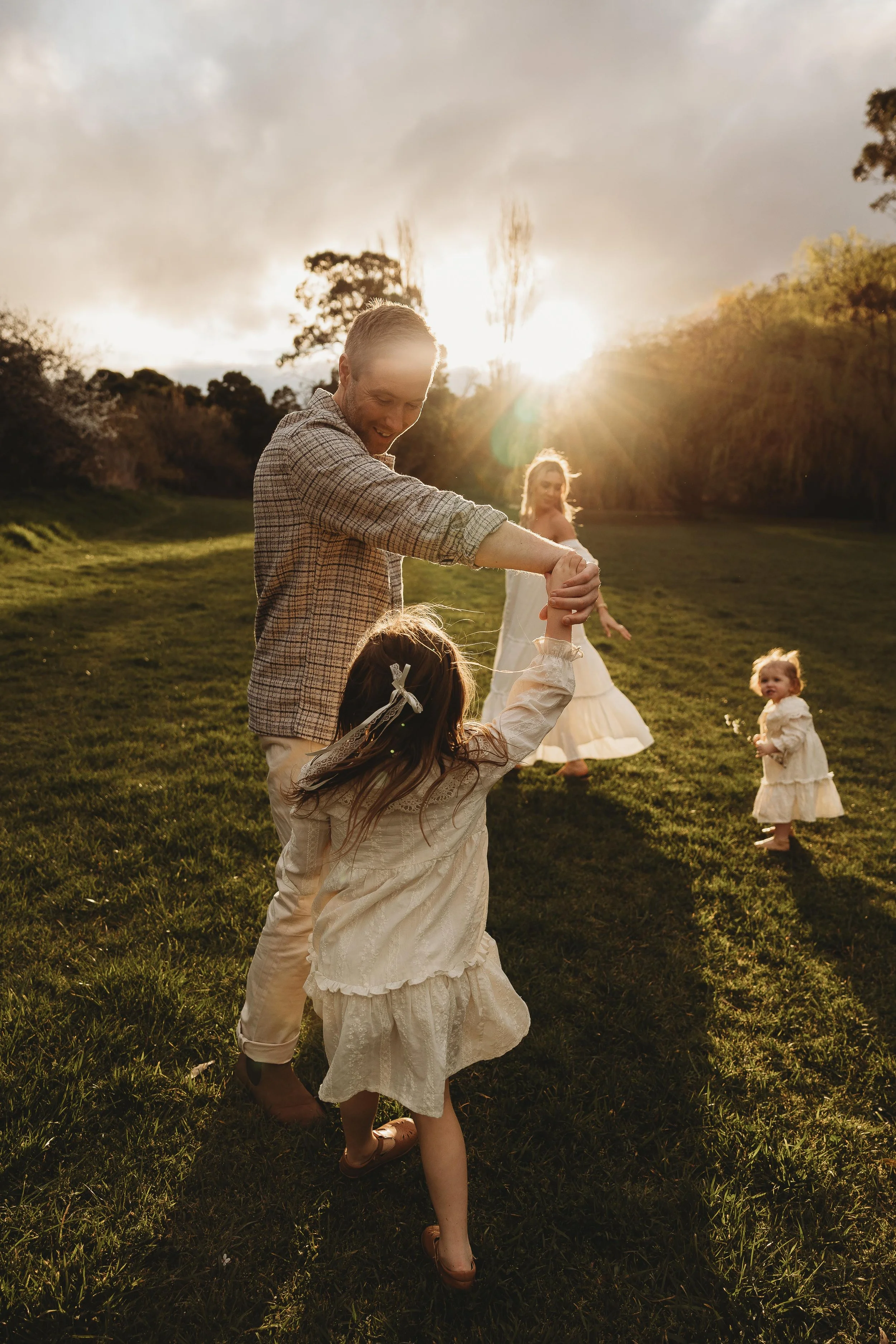 family enjoying sunset with dad spinning daughter