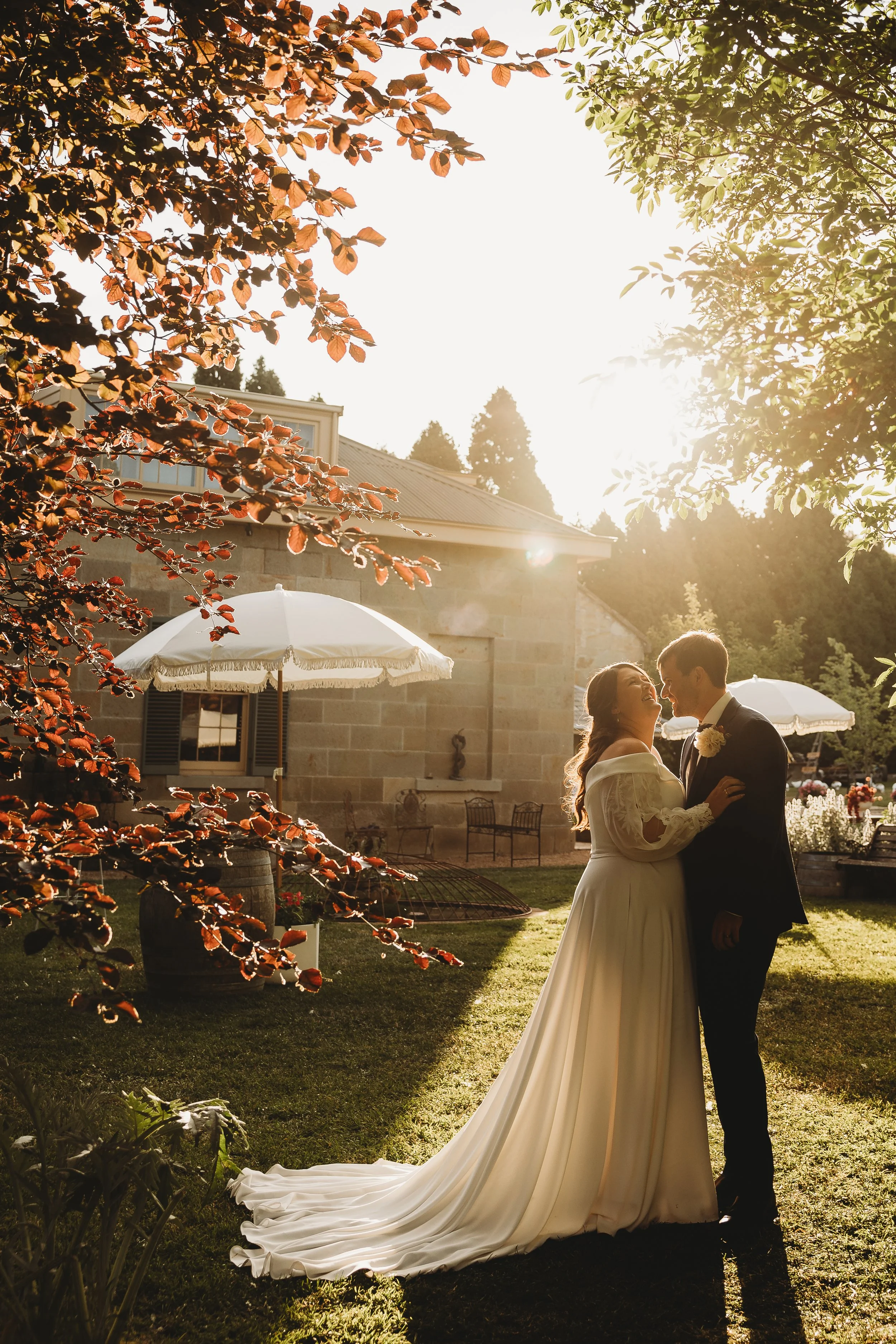 bride and groom embracing in the golden light amoungst the garden 