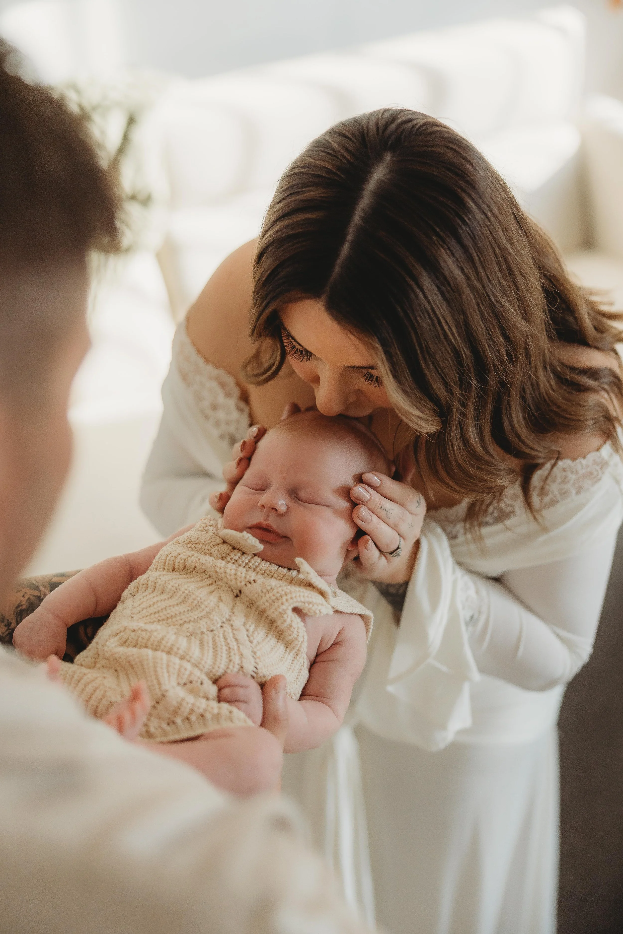 mum kissing newborn baby on the head