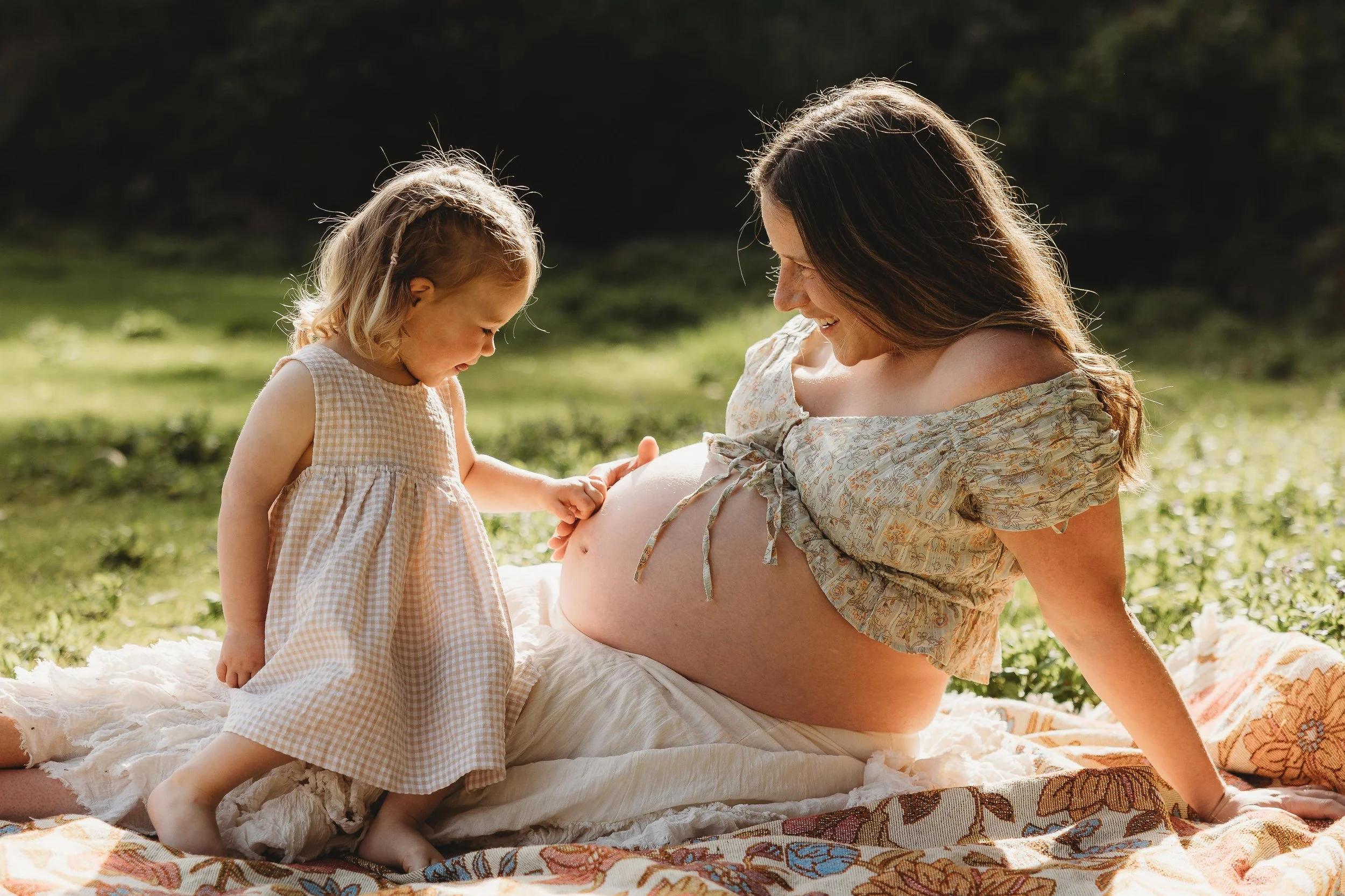 mum and daughter in open field cuddling pregnant belly - Expose photography Hobart Photographer