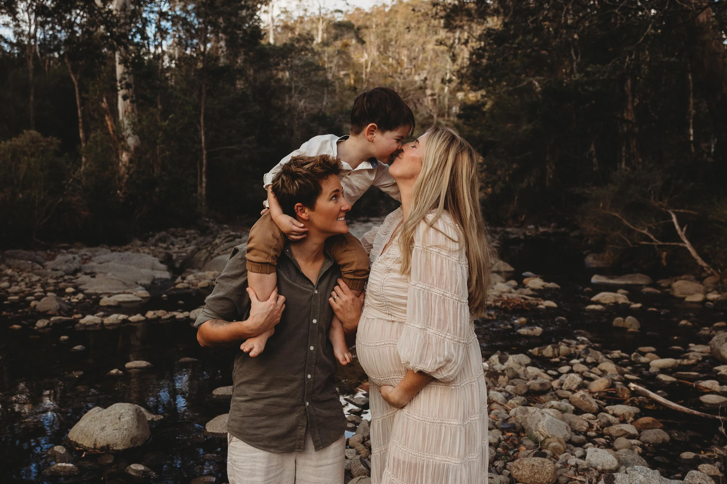 mothers with young boy cradling pregnant belly