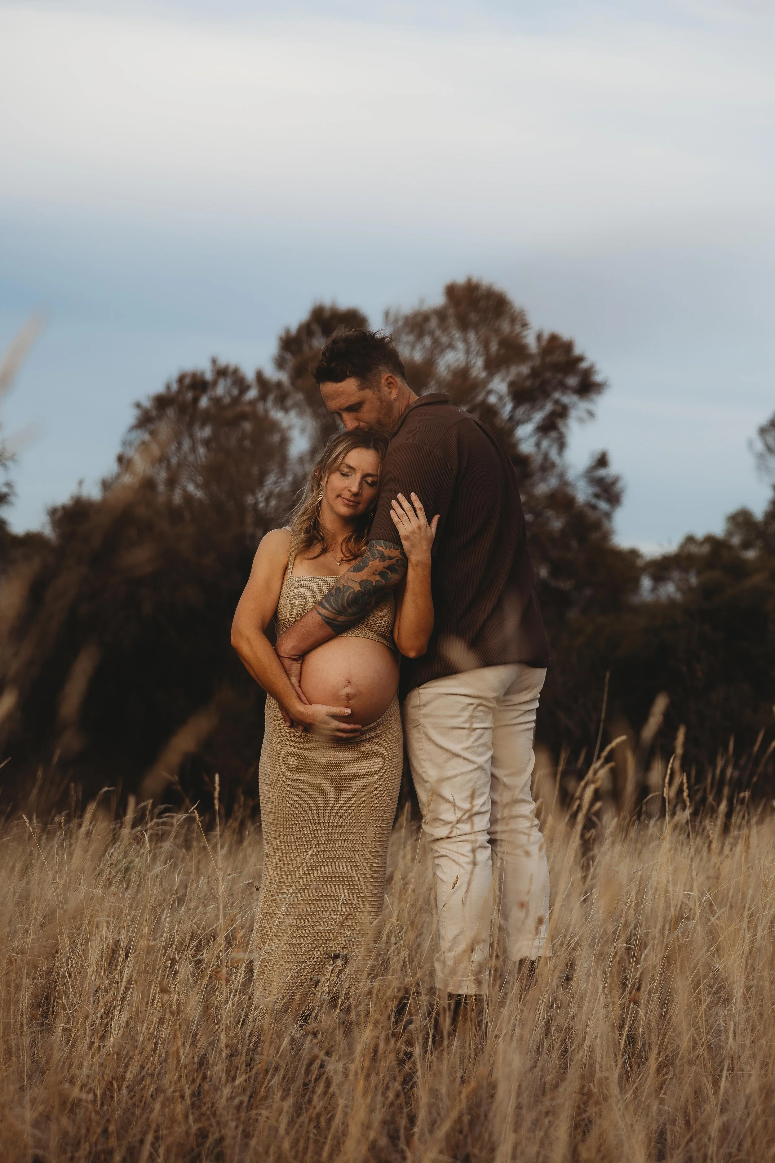 man and pregnant women in a field