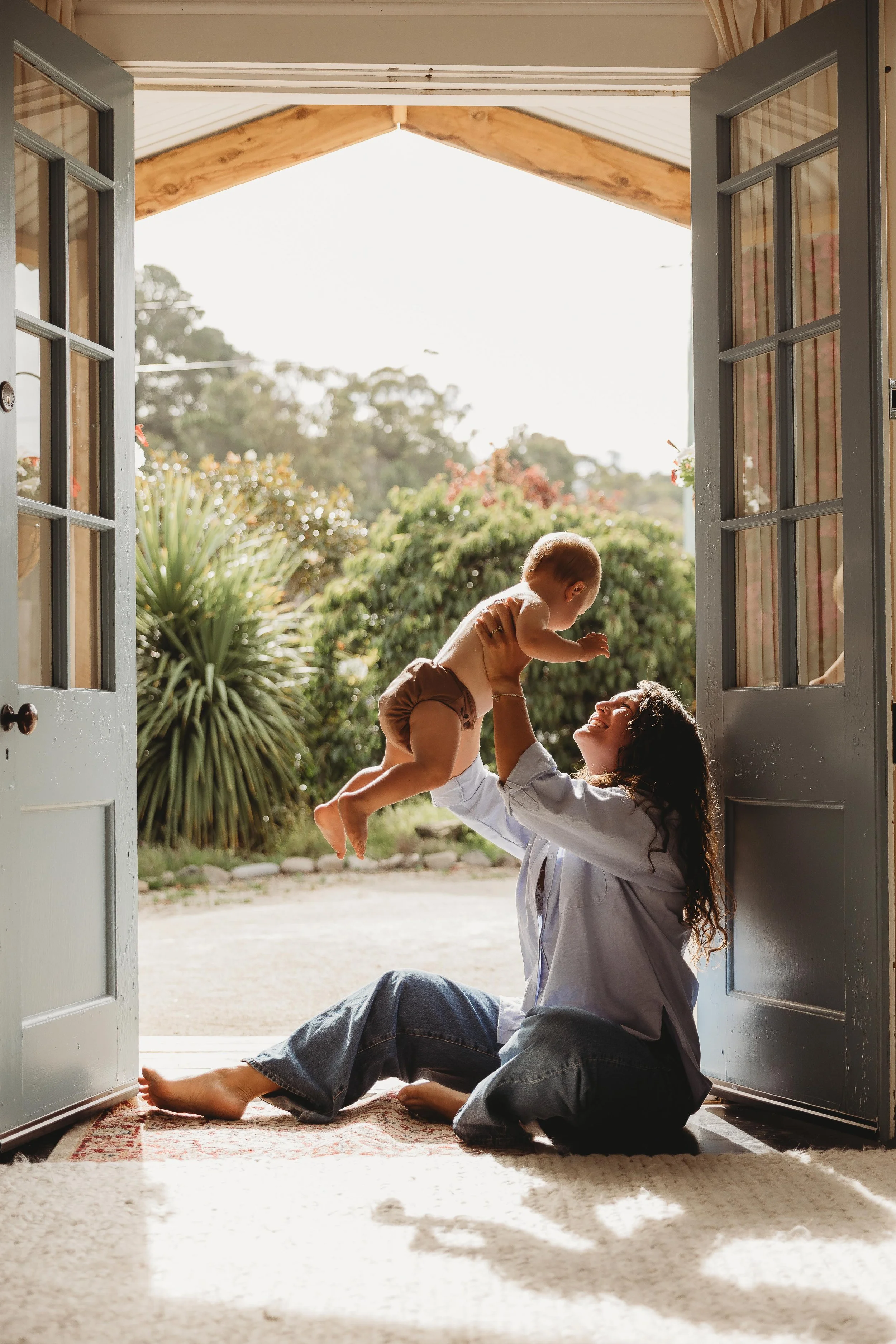 mother and son sitting in doorway playing aeroplanes