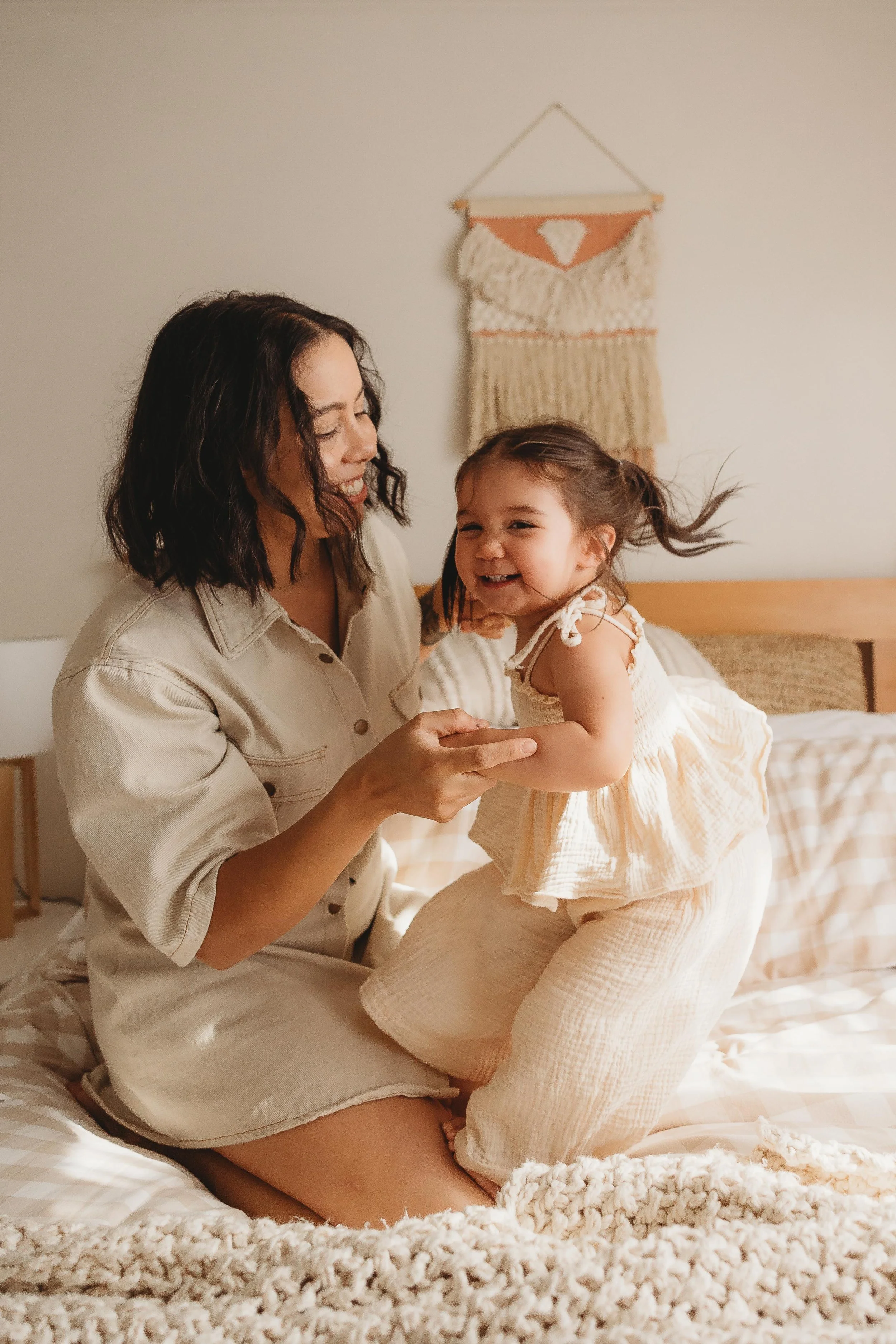 Mum and Daughter jumping on bed