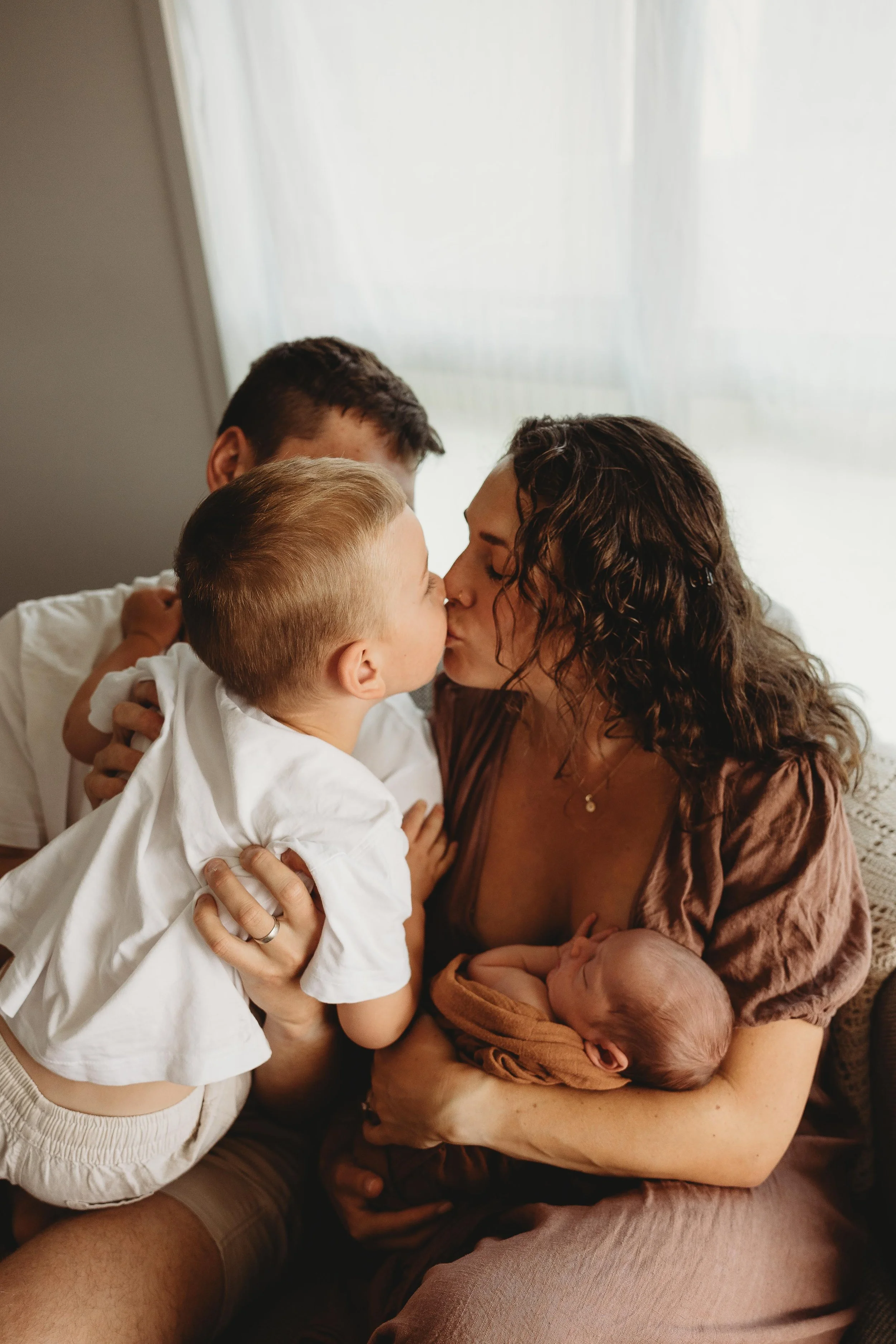 family all together adoring newborn baby