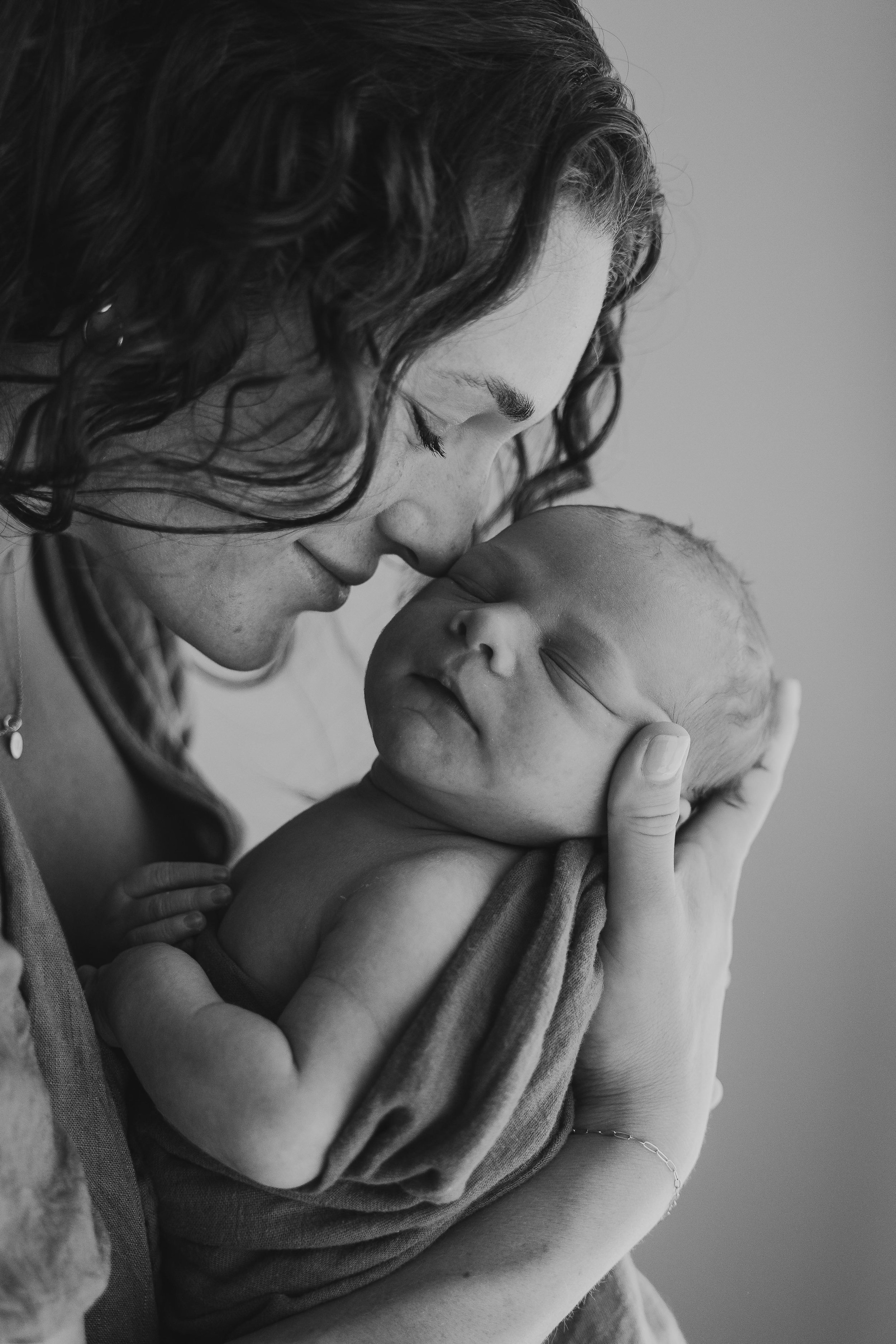 mother embracing newborn baby