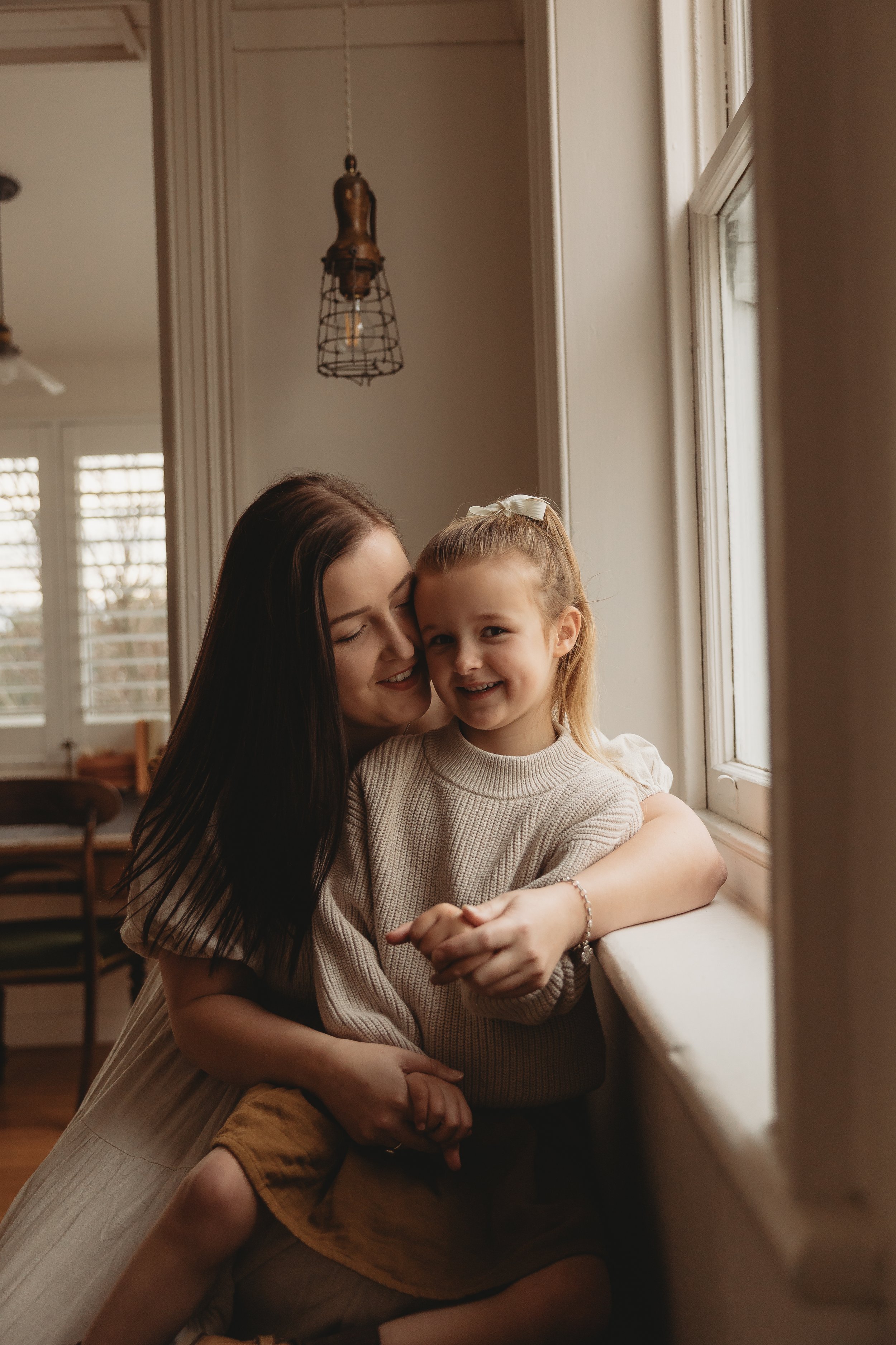 Mum and daughter sitting near window talking